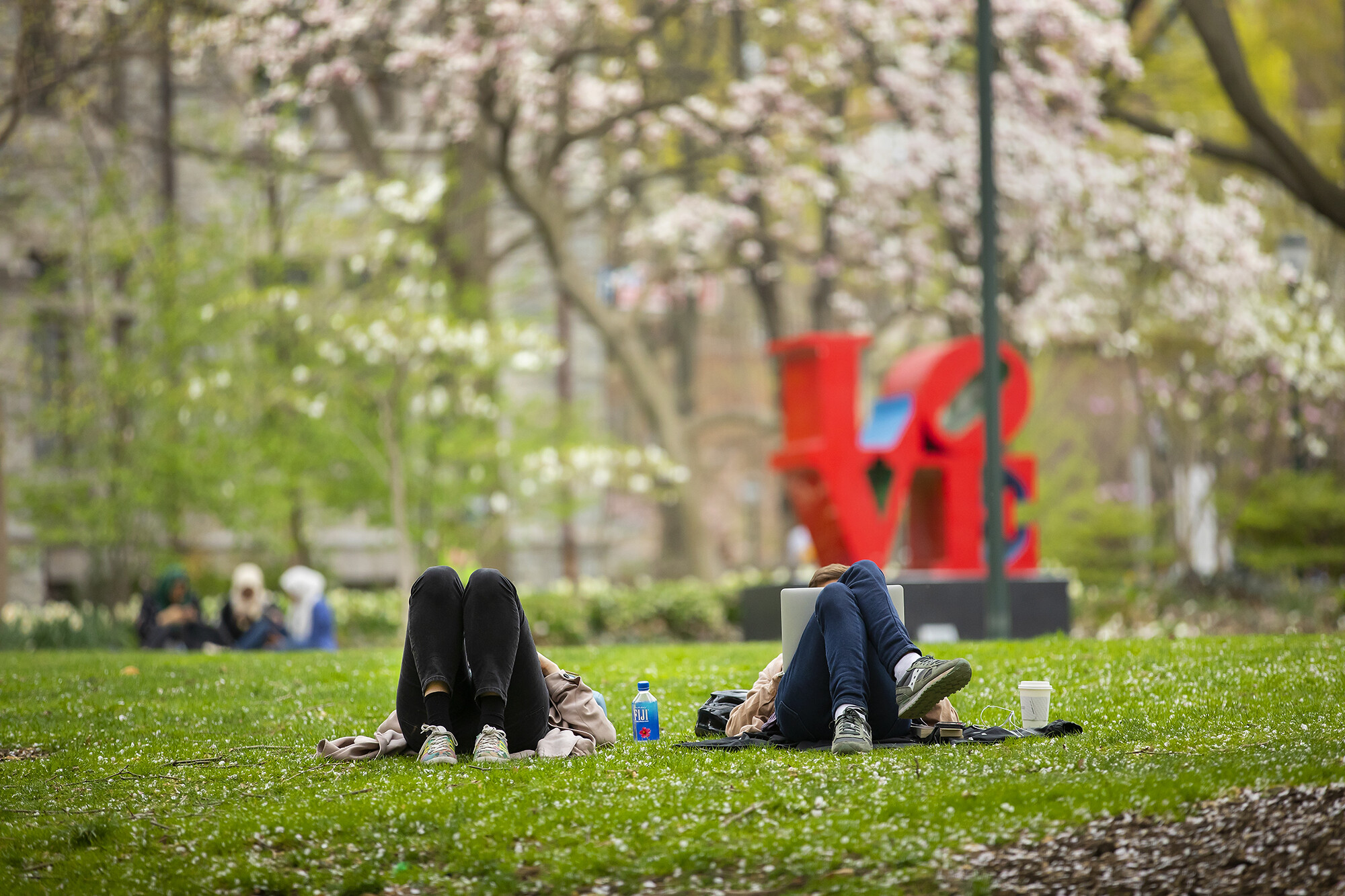 students on college green near love statue