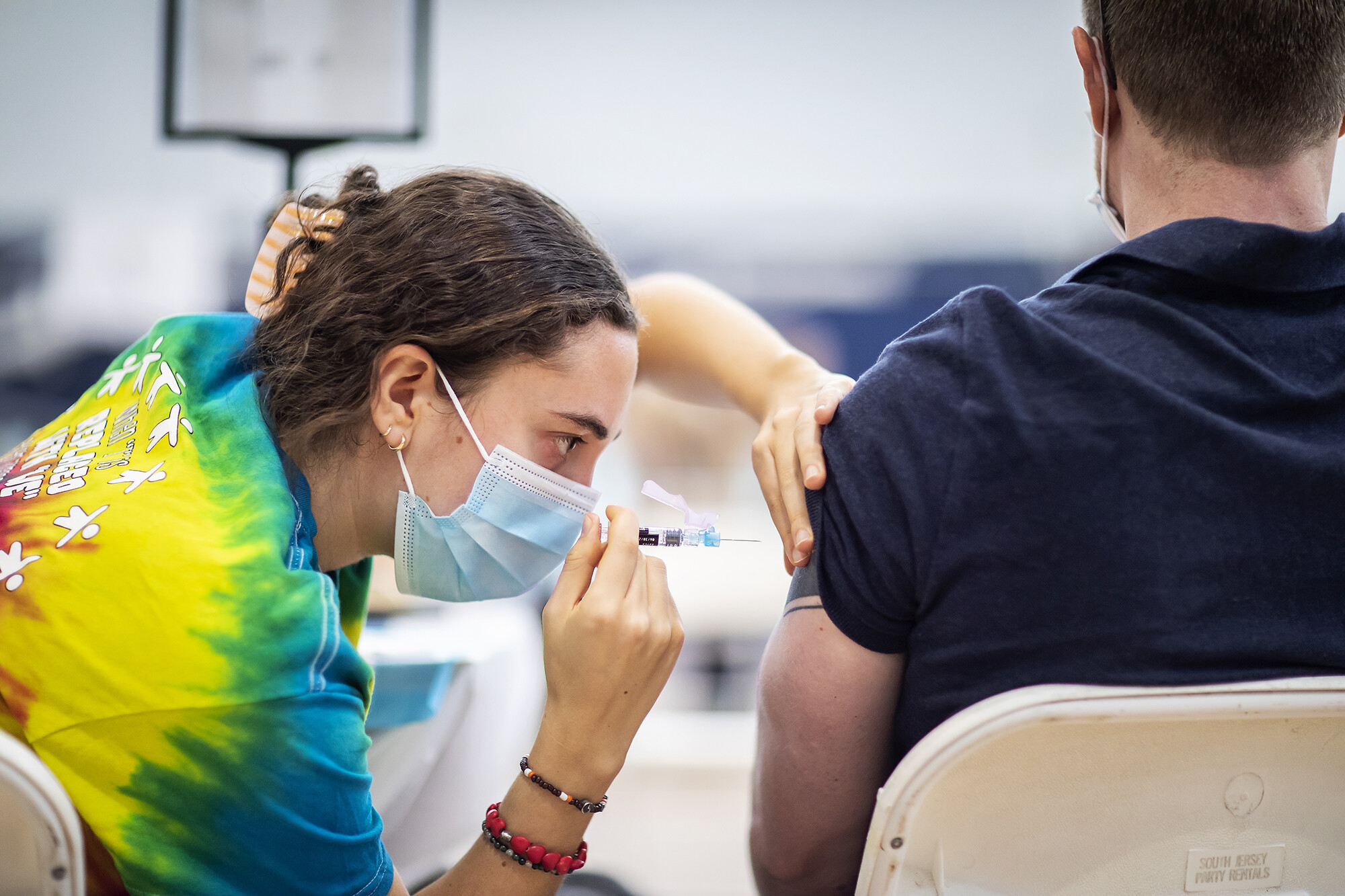 health care worker injects vaccine into patient's arm