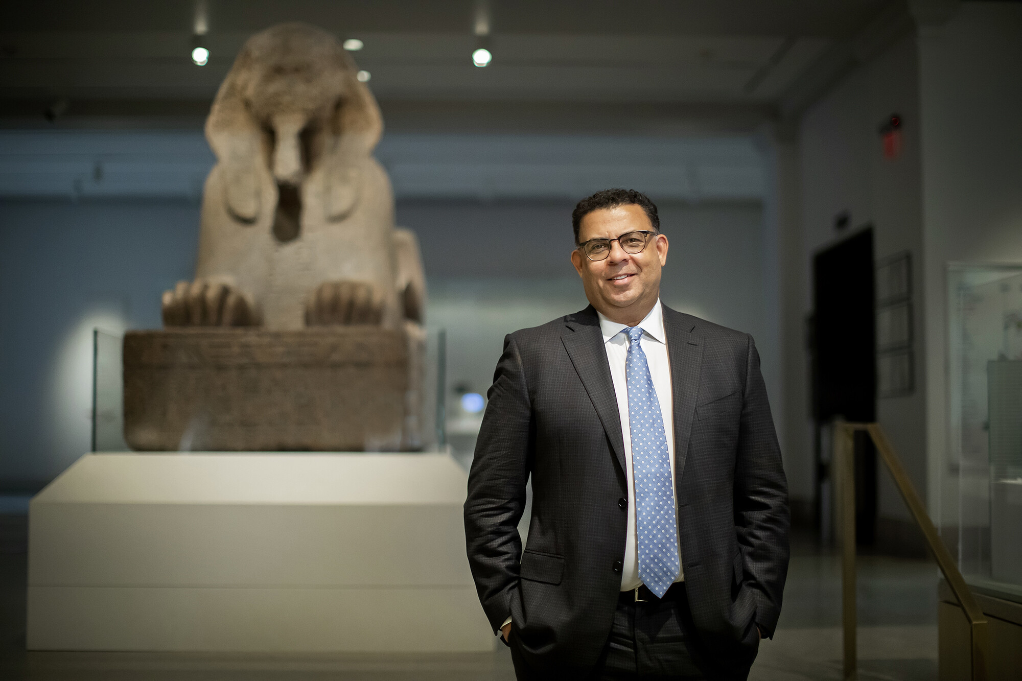Person standing in front of a sphinx in a museum 