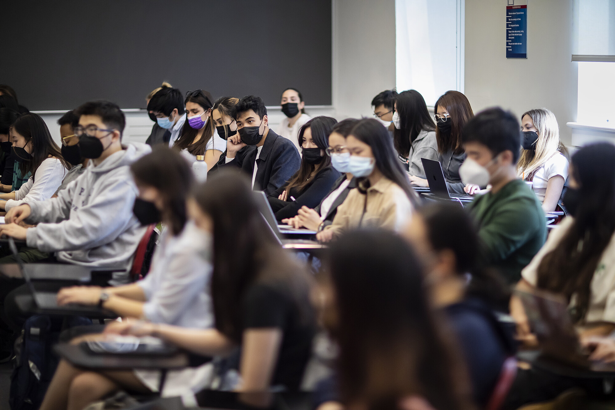 Rows of students take notes during class