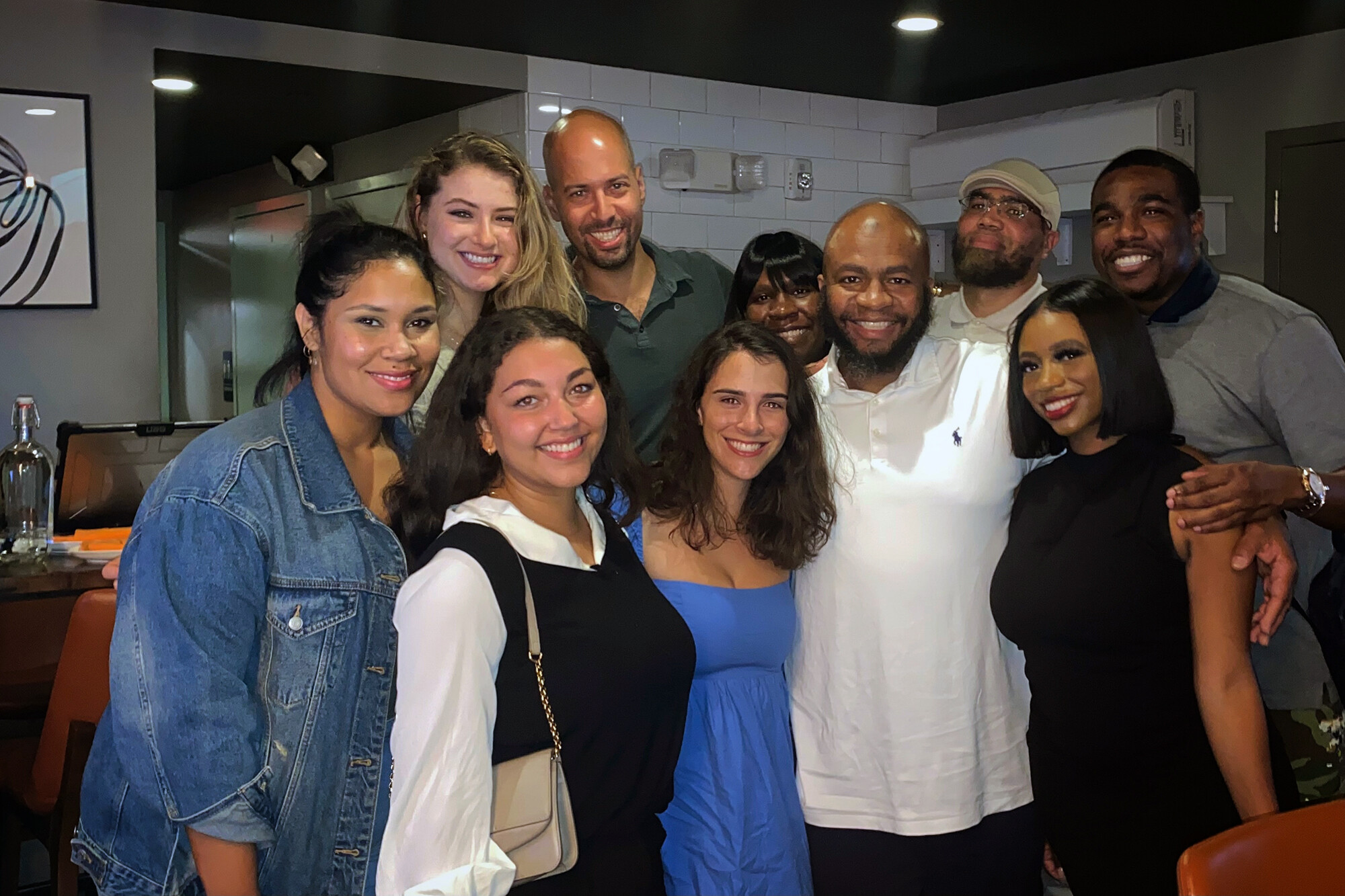 A group of people with their arms around each other, smiling.