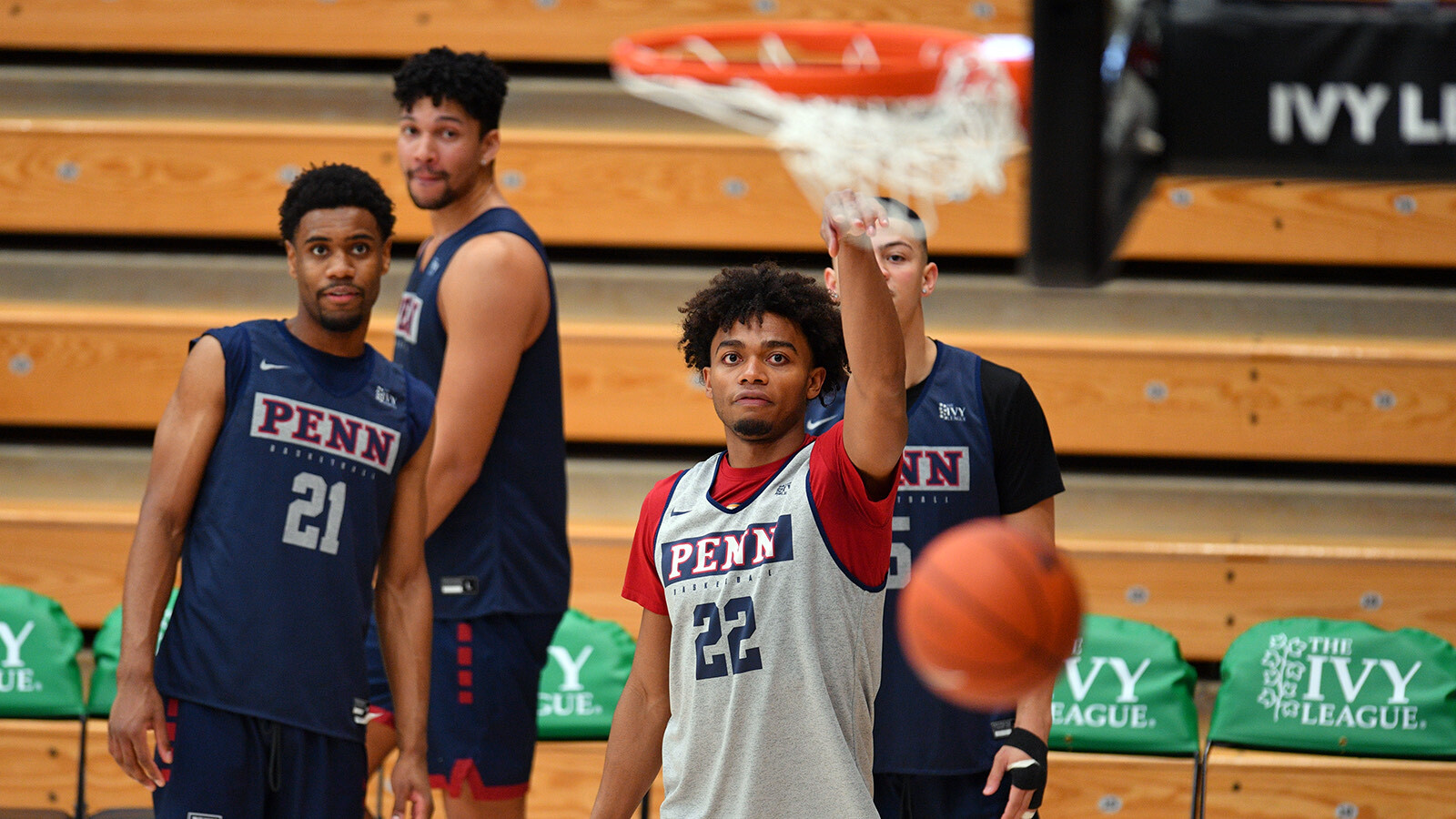 Lucas Monroe makes a one-handed shot while teammates look on 