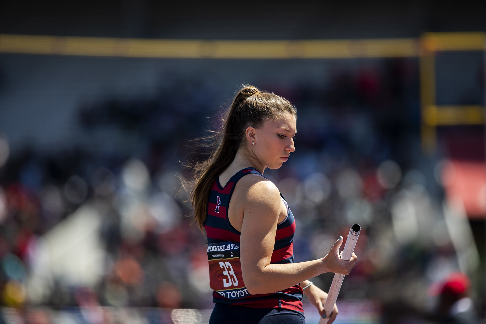 An athlete holds a pole vault pole in their hands.
