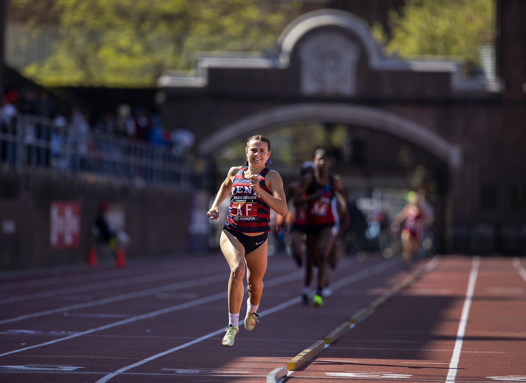 A runner running in the lead on a track.