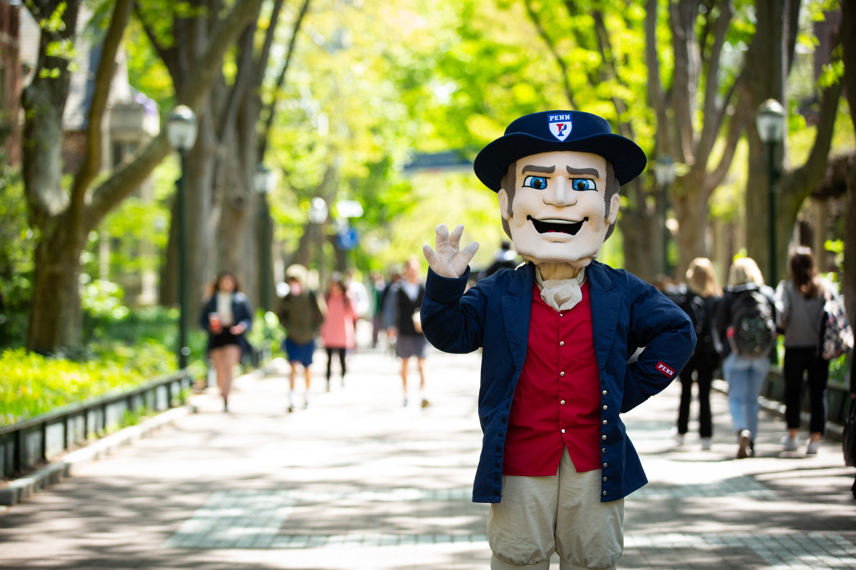 The Penn Quaker mascot waves on Locust Walk.