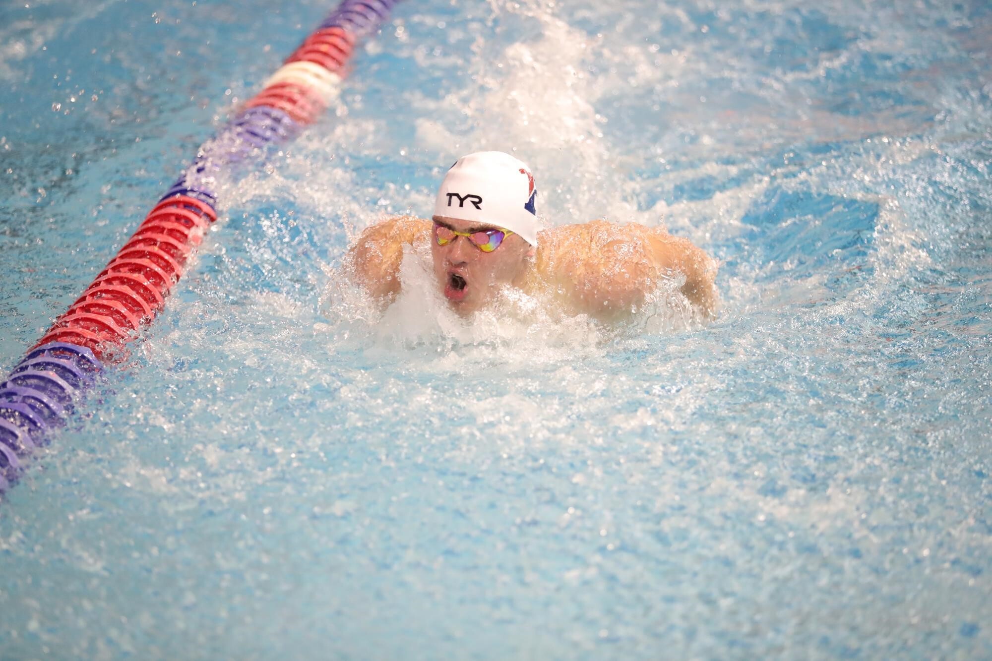 Fallon swins in a pool during a race, coming up for a breath.