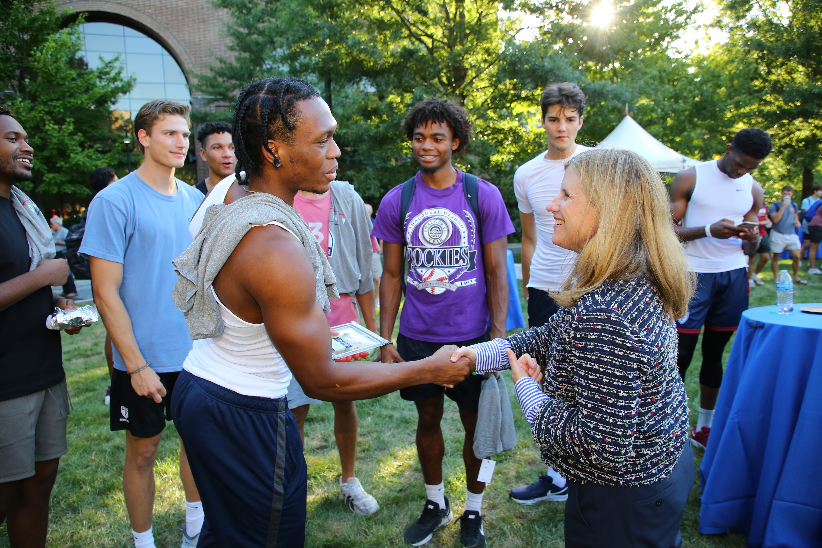 President Liz Magill greets Jordan Dingle of the men’s basketball team.