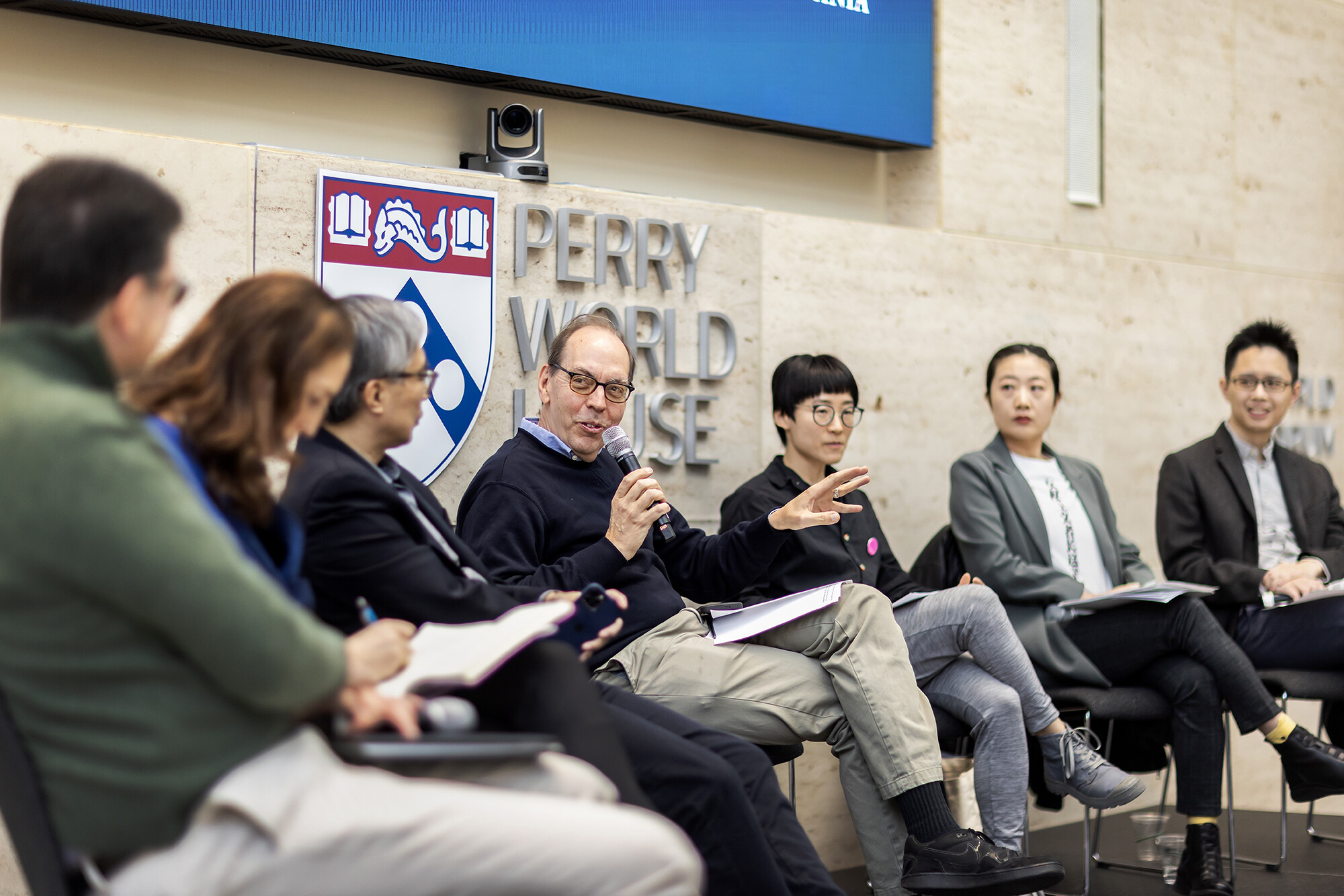 Director of the Center for the Study of Contemporary China, Jacques deLisle, holds a microphone as he speaks on a panel with other experts about the China protests