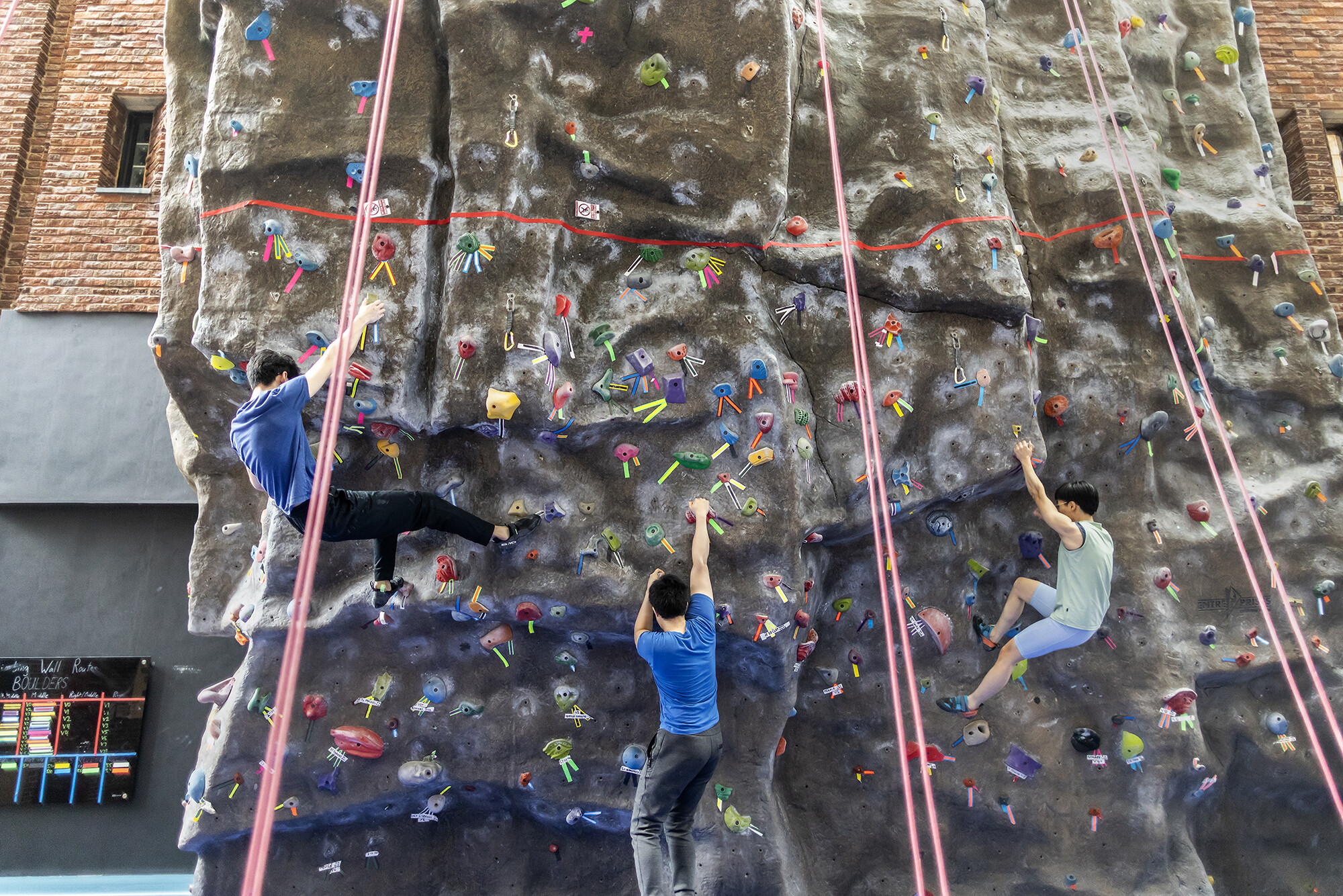 Three members negotiate the 40-foot climbing wall at the Pottruck Center on Friday, Jan. 20.