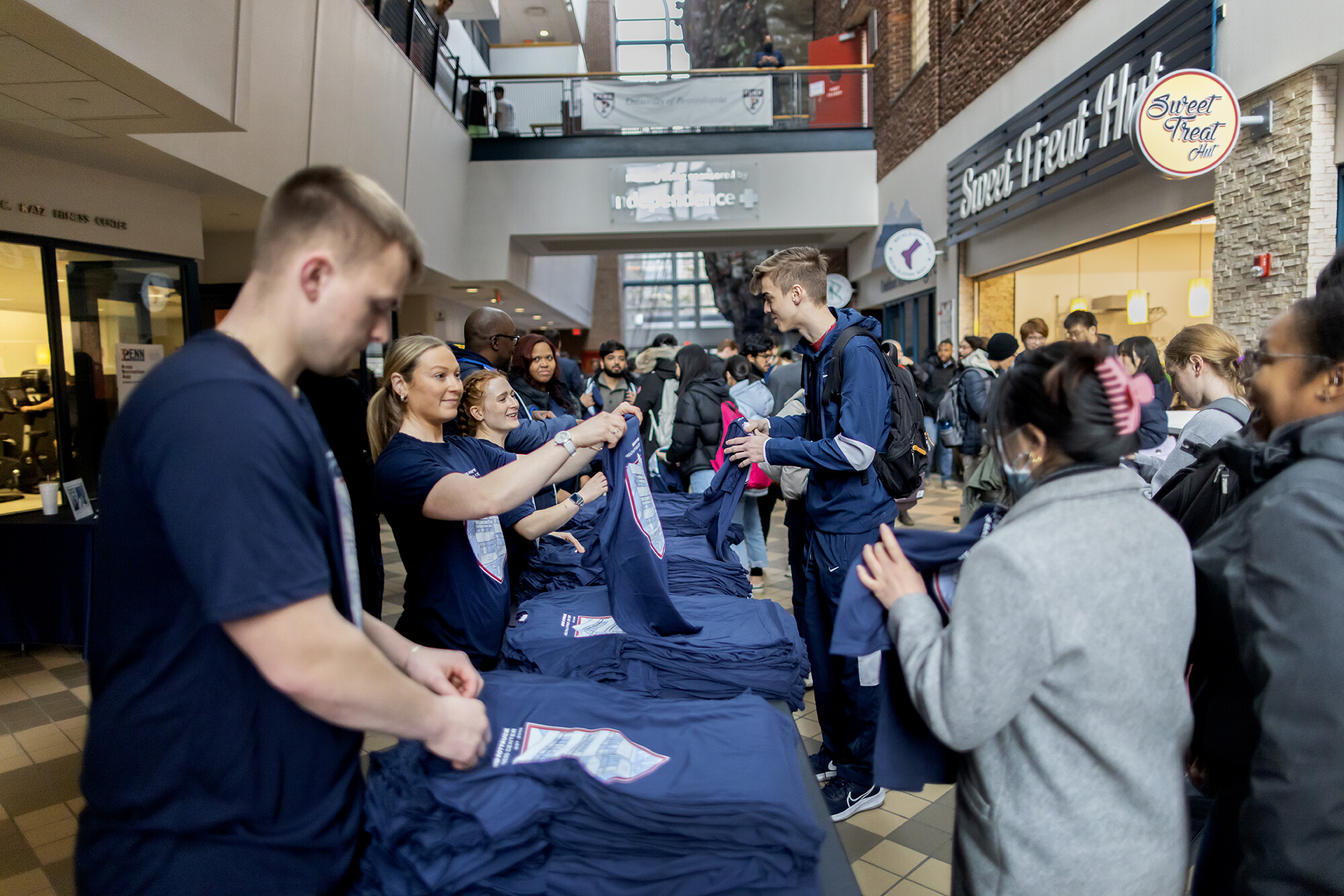 Morgen Rosen (second from left), coordinator of fitness & wellness at Penn Campus Recreation, hands out T-shirts during the Pottruck Center birthday bash on Friday, Jan. 20.