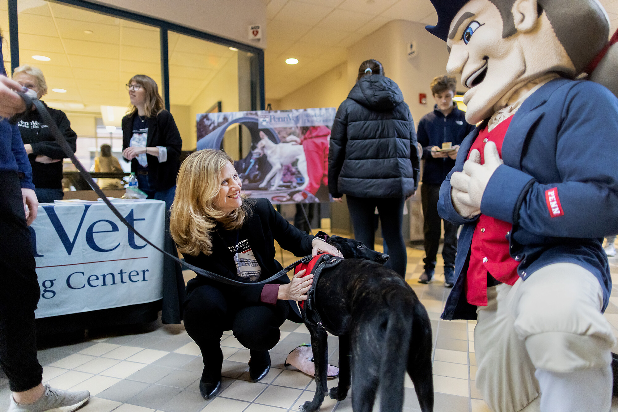 During the Pottruck Center birthday bash on Friday, Jan. 20, President Liz Magill greets Kozi, a seven-month old Dutch Shepherd from the Penn Vet Working Dog Center, which touches the Penn Quaker’s heart.