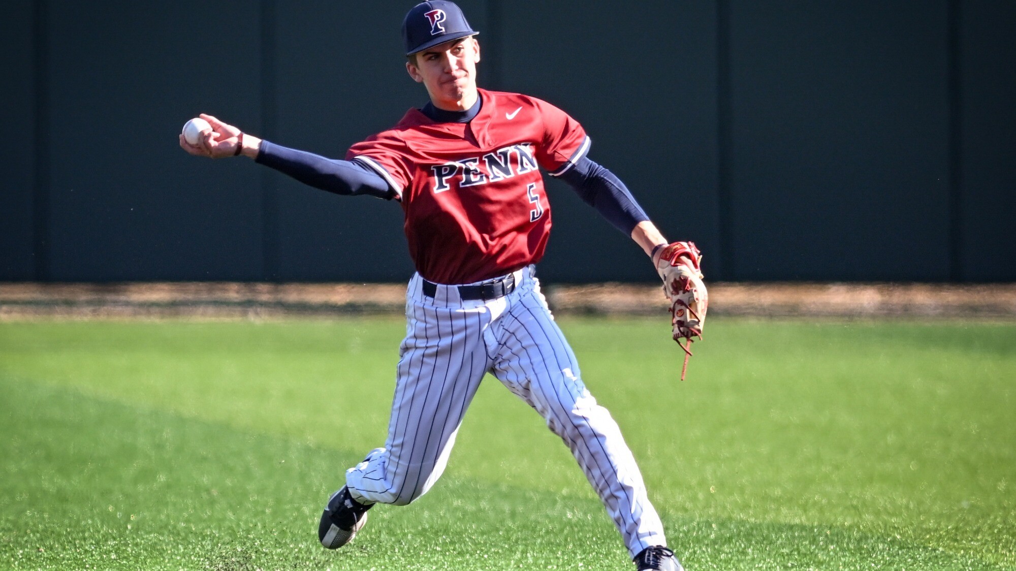 during a game, Taylor leaps and throws the ball to the infield.