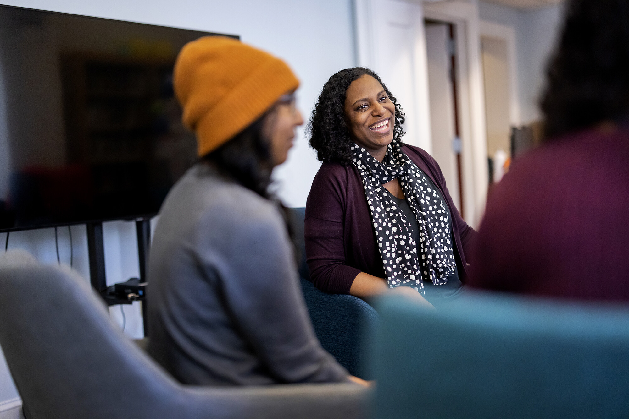 Framed between 2 students, Elisa Foster laughs during a planning meeting