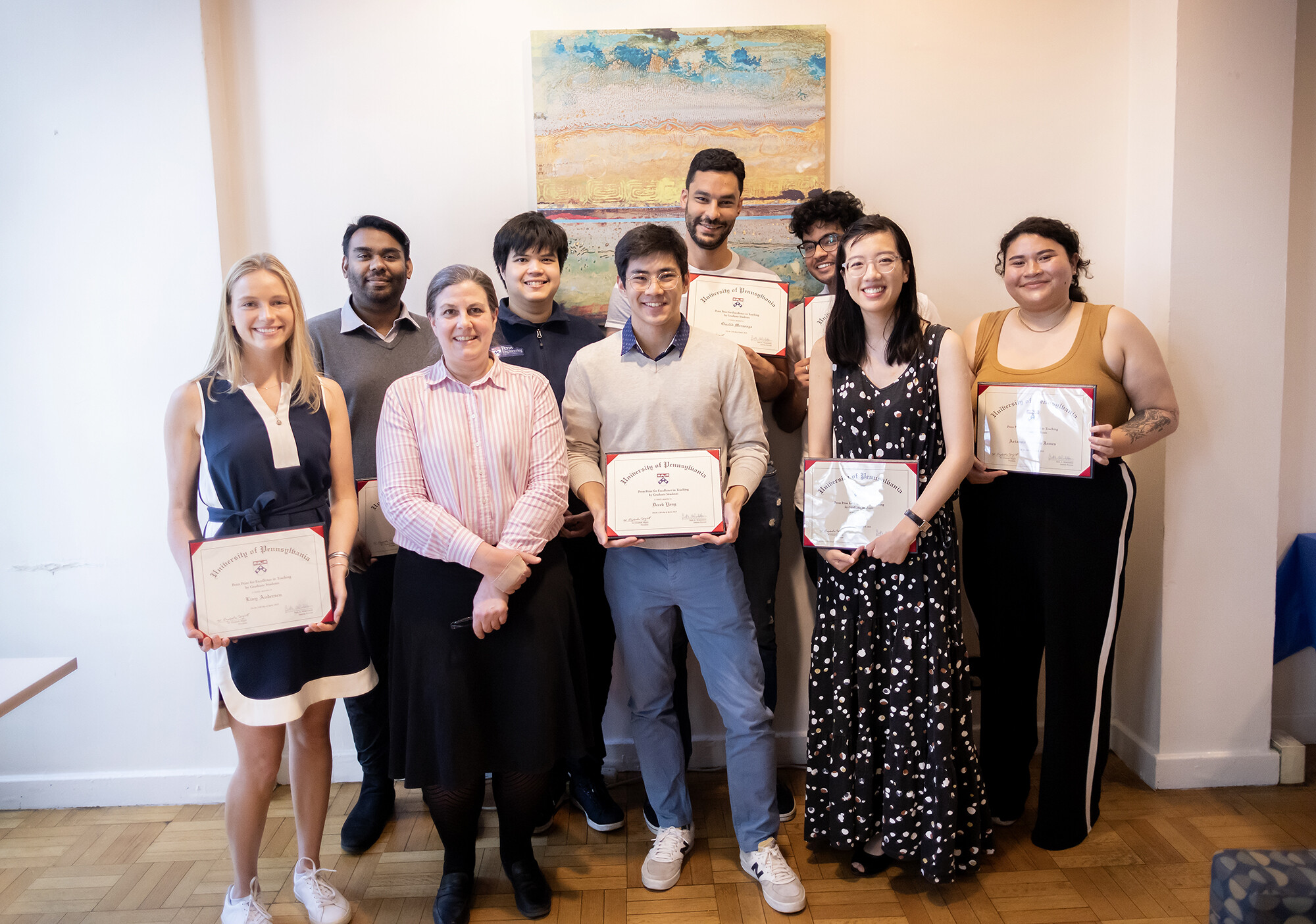 A group of students clustered around each other holding certificates. 