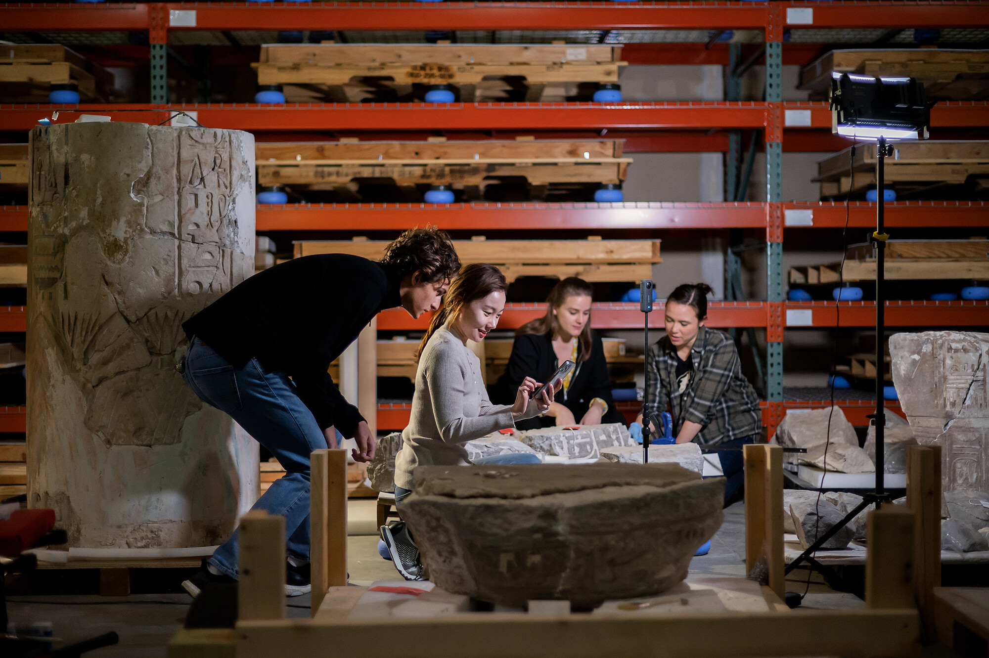Four students working in the Museum warehouse on a VR project.
