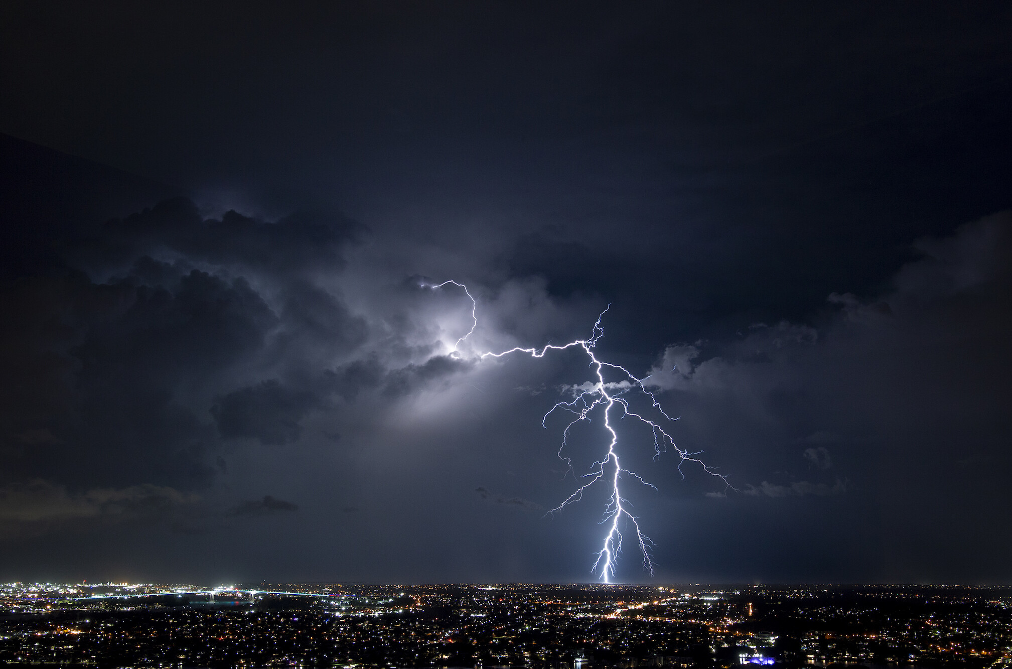 Photo of lightening striking a city at night.