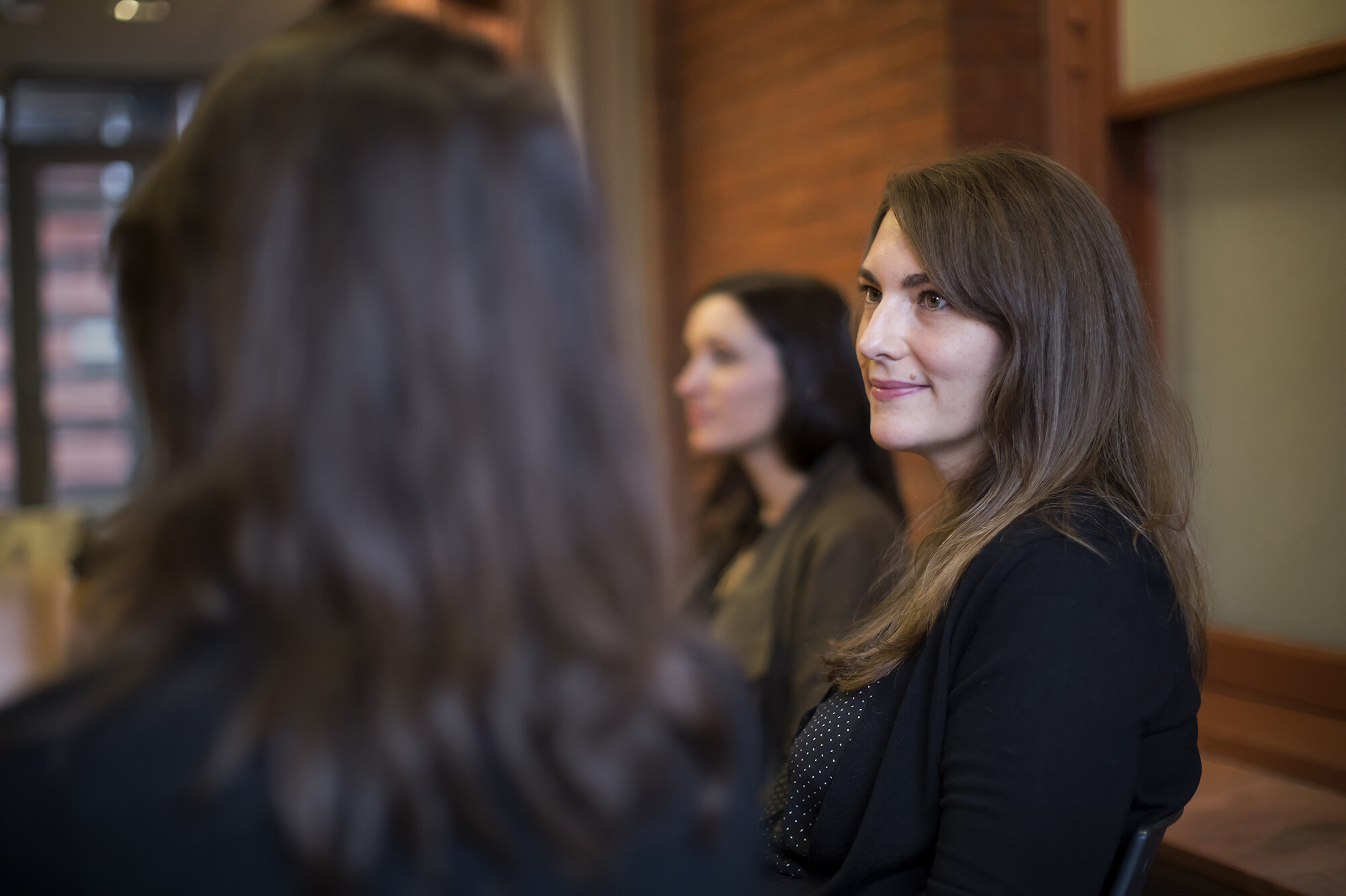Historian Ada Kuskowski listens to a speaker sitting next to her at a table.