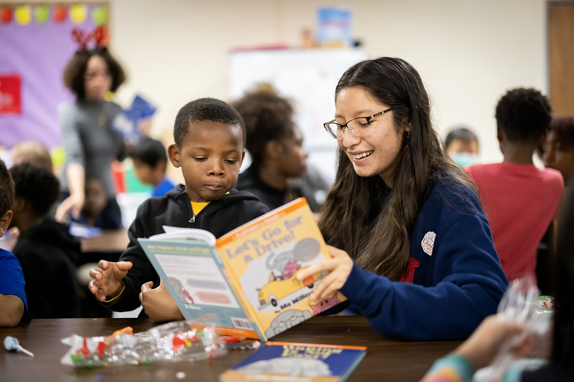 Andrea Barajas reads Mo Willems' "Let's Go for a Drive!" to a student
