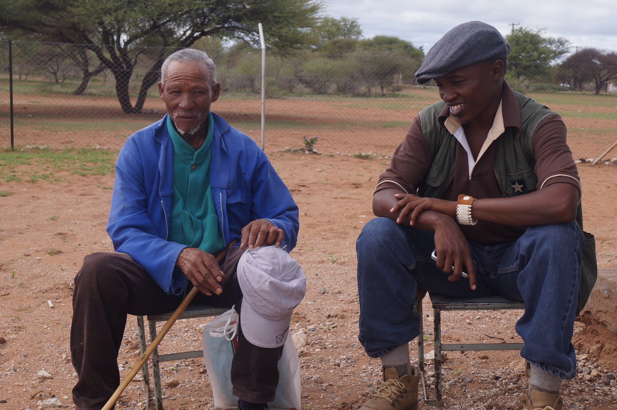 Two men sitting and smiling for a photgraph