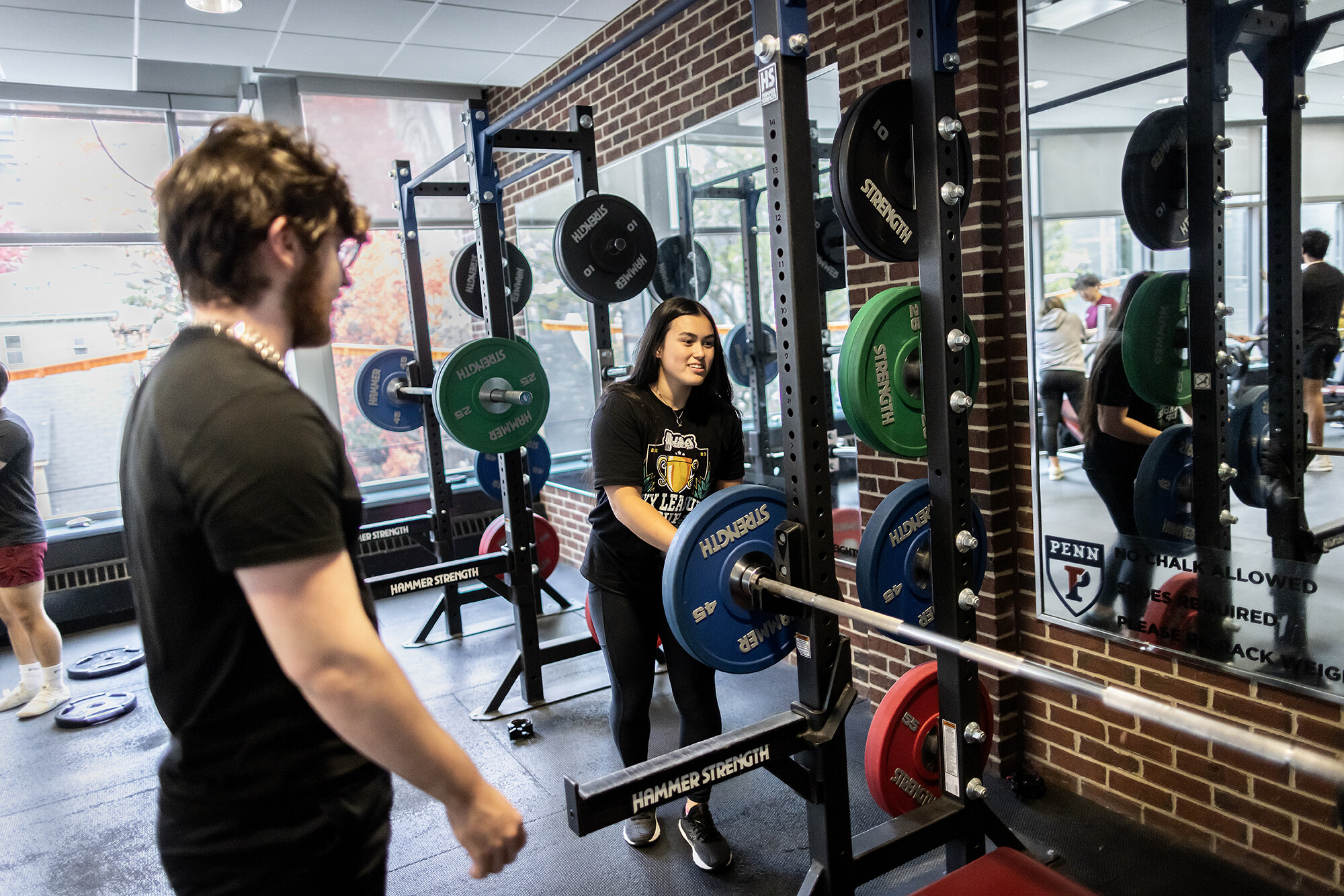 Adrienna Davis, a third-year economics major in the School of Arts & Sciences (SAS), racks a 45-pound plate onto a bar.