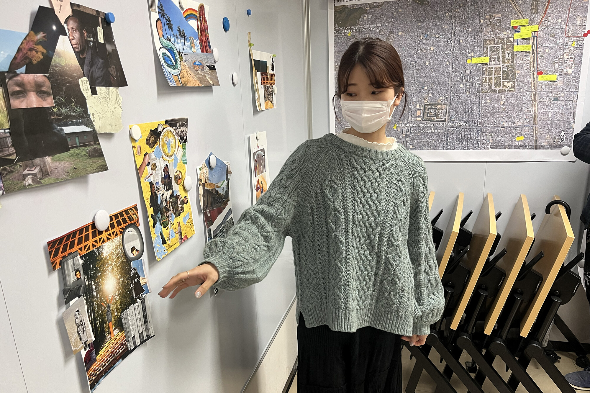A student points to artwork on a wall.