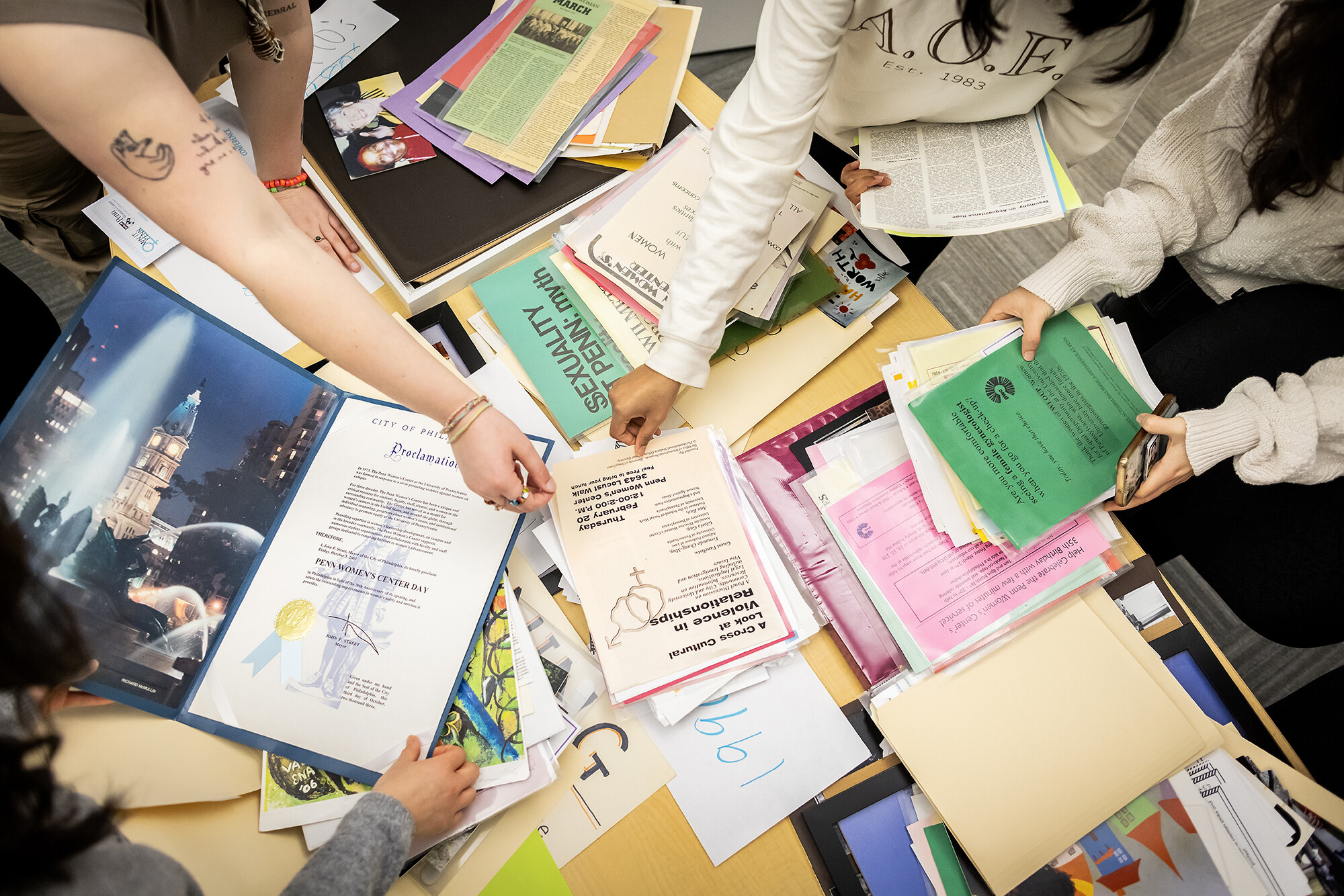 Three students looking at gender, sexuality, and women’s studies archival material.