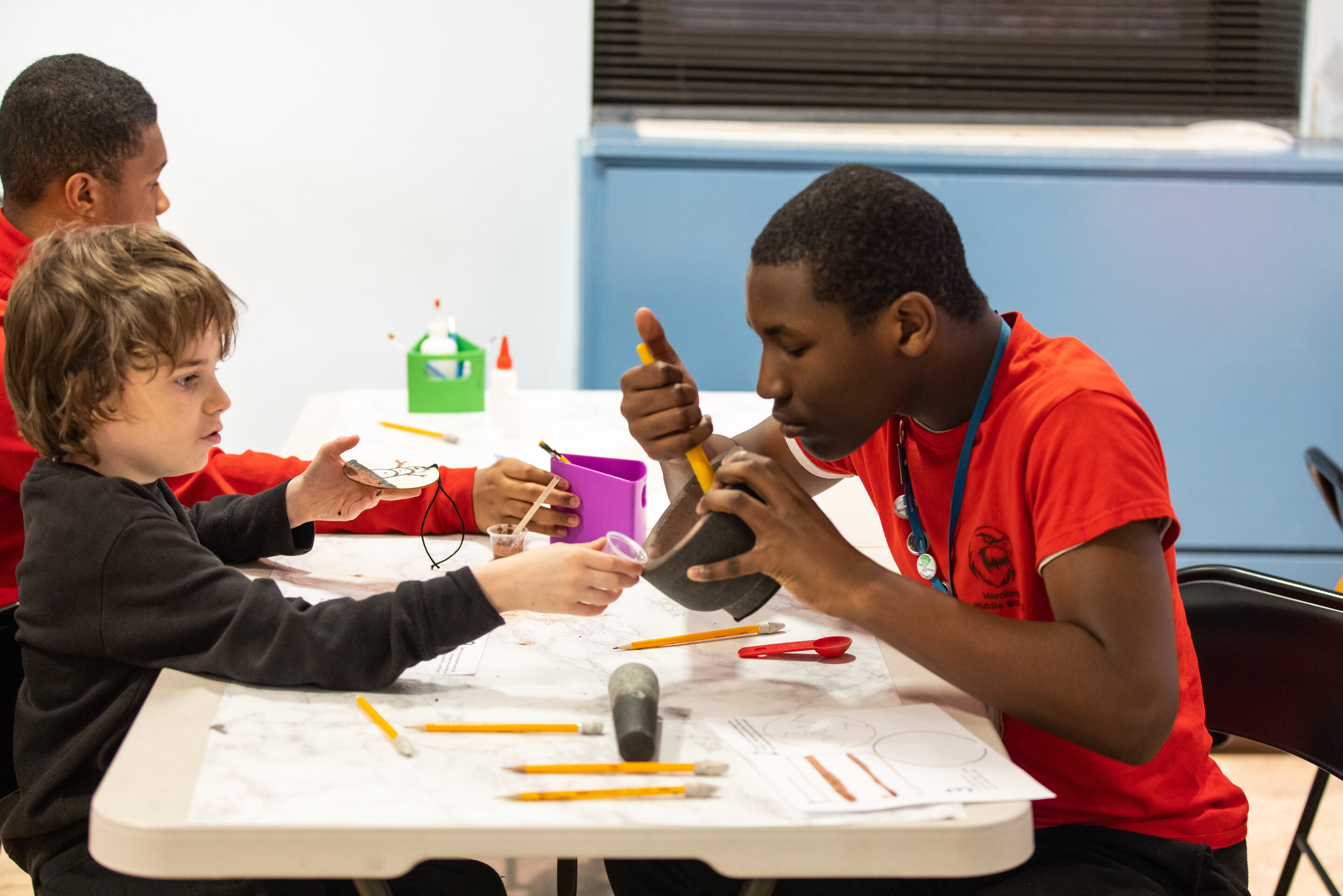 Three young people doing crafts at  the Penn Museum.