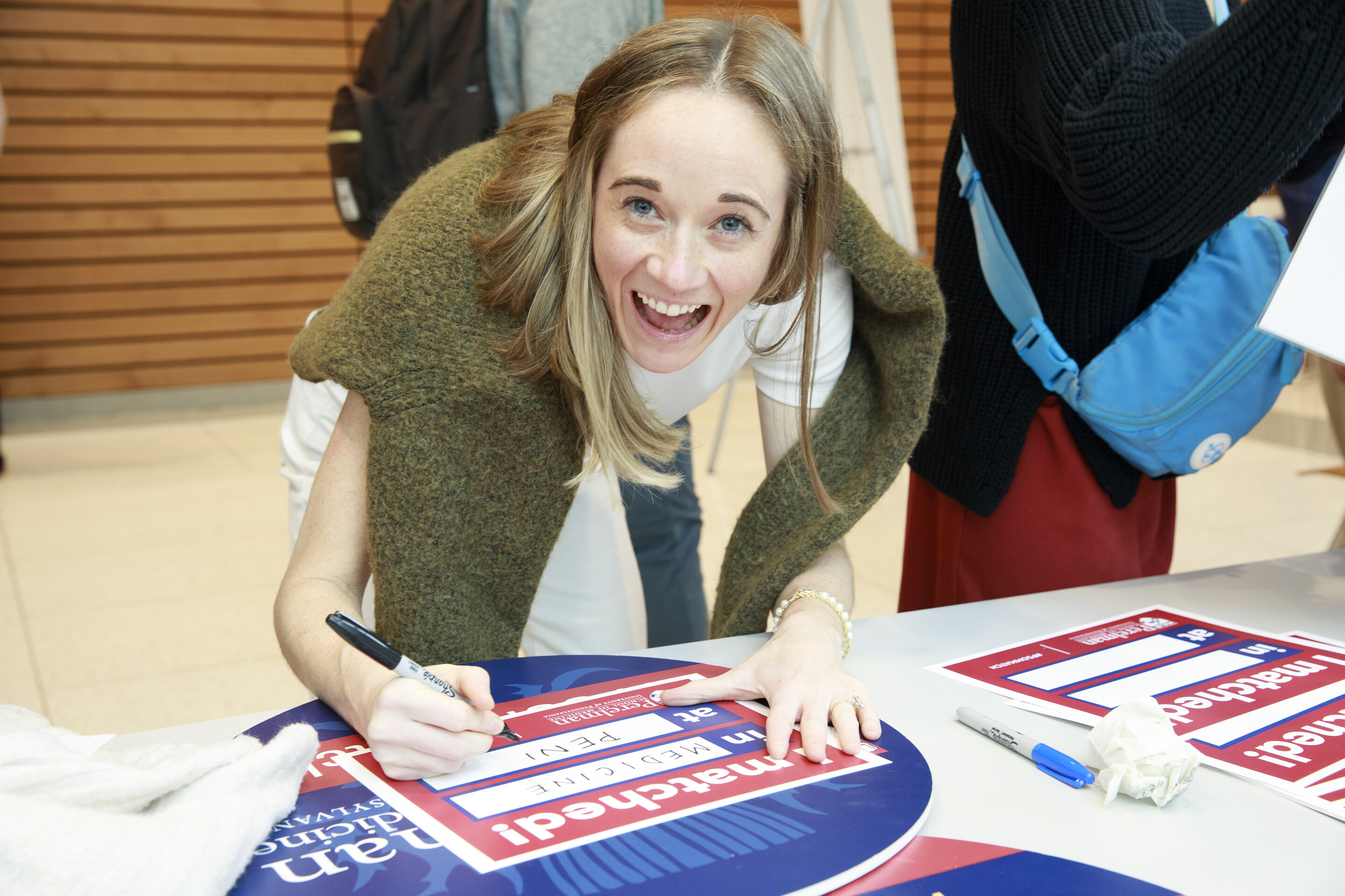 A Penn Med student writes on their Match Day sign.