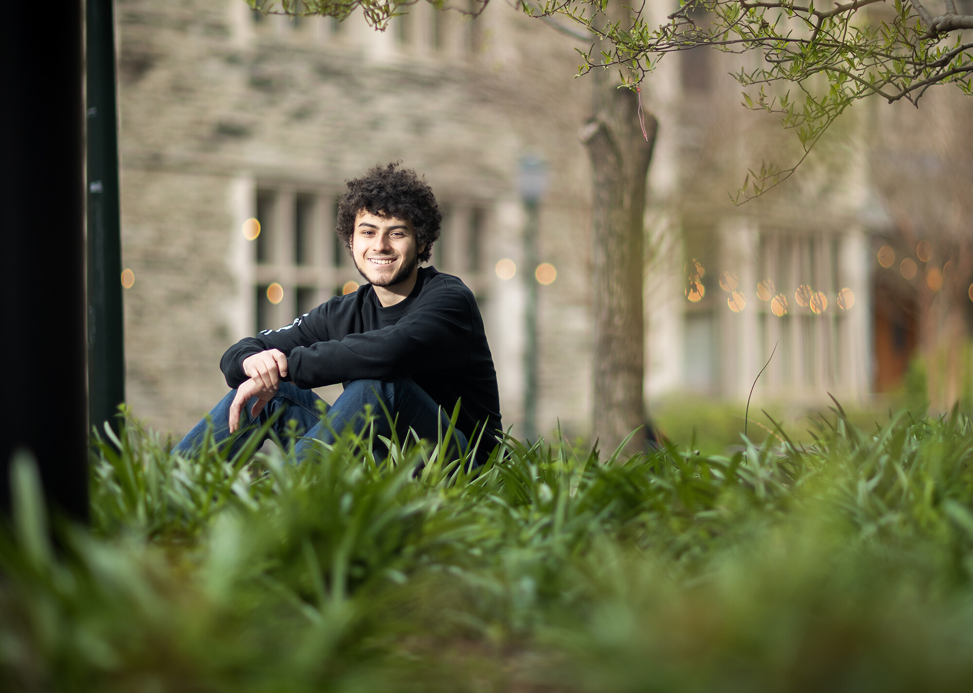 Mostafa Afr sitting outside in the grass.