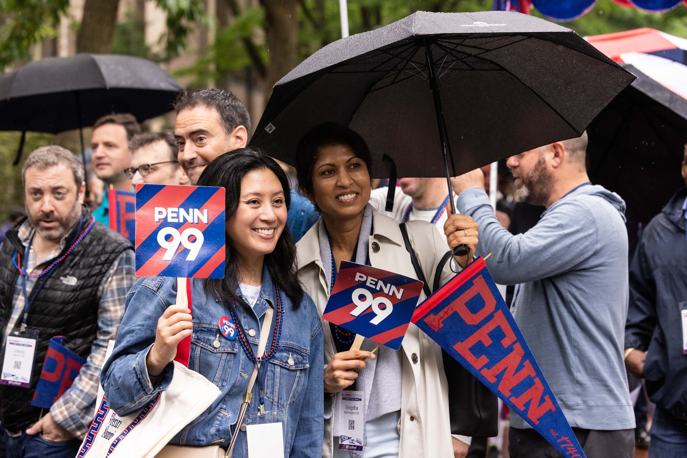 alumni hold Penn '99 signs and umbrella for Alumni Parade