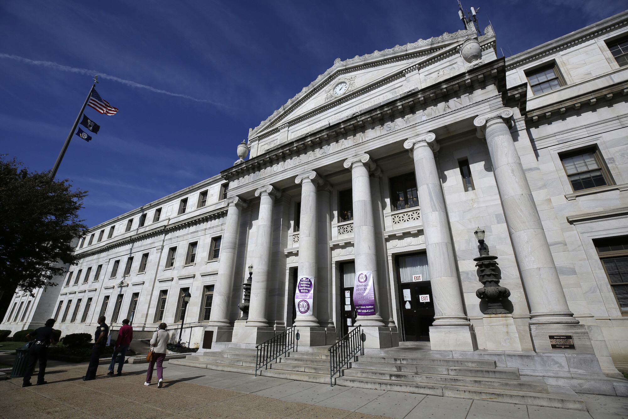 Image is of the Delaware County courthouse, a Classical Revival/Neo-Classical style building made of white marble,with a six column portico and clock in the pediment, located in Media, Pennsylvania.