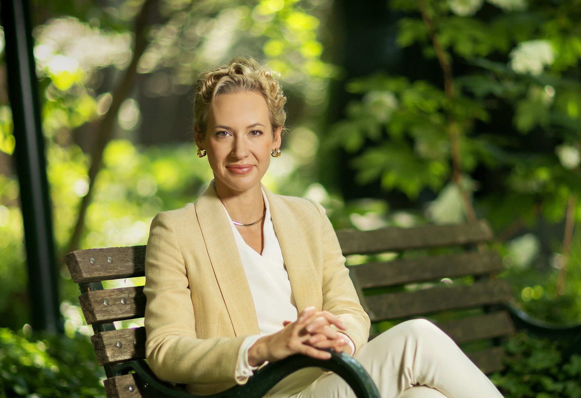 Brigitte Weinsteiger sits with hands crossed on a park bench