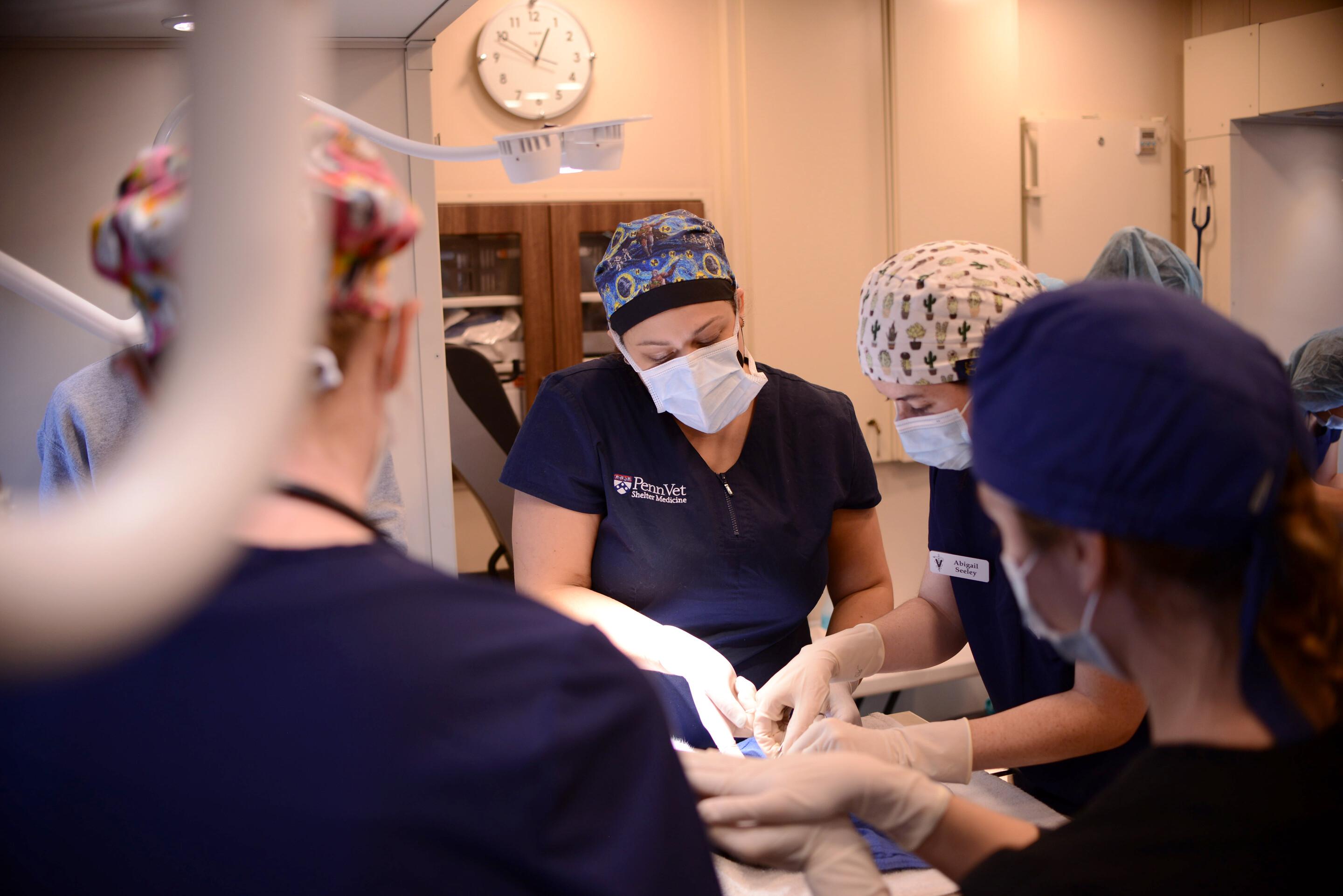 A clinical room with five people scrubbed in, with Brittany Watson in the center