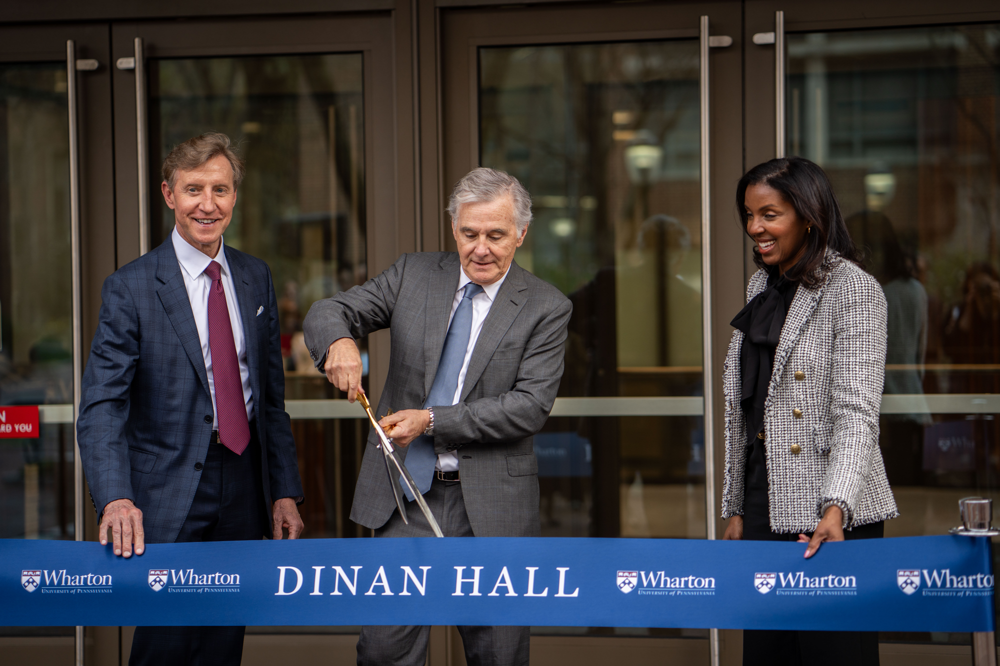 J. Larry Jameson, Erika H. James and Jamie Dinan stand in front of Dinan Hall.