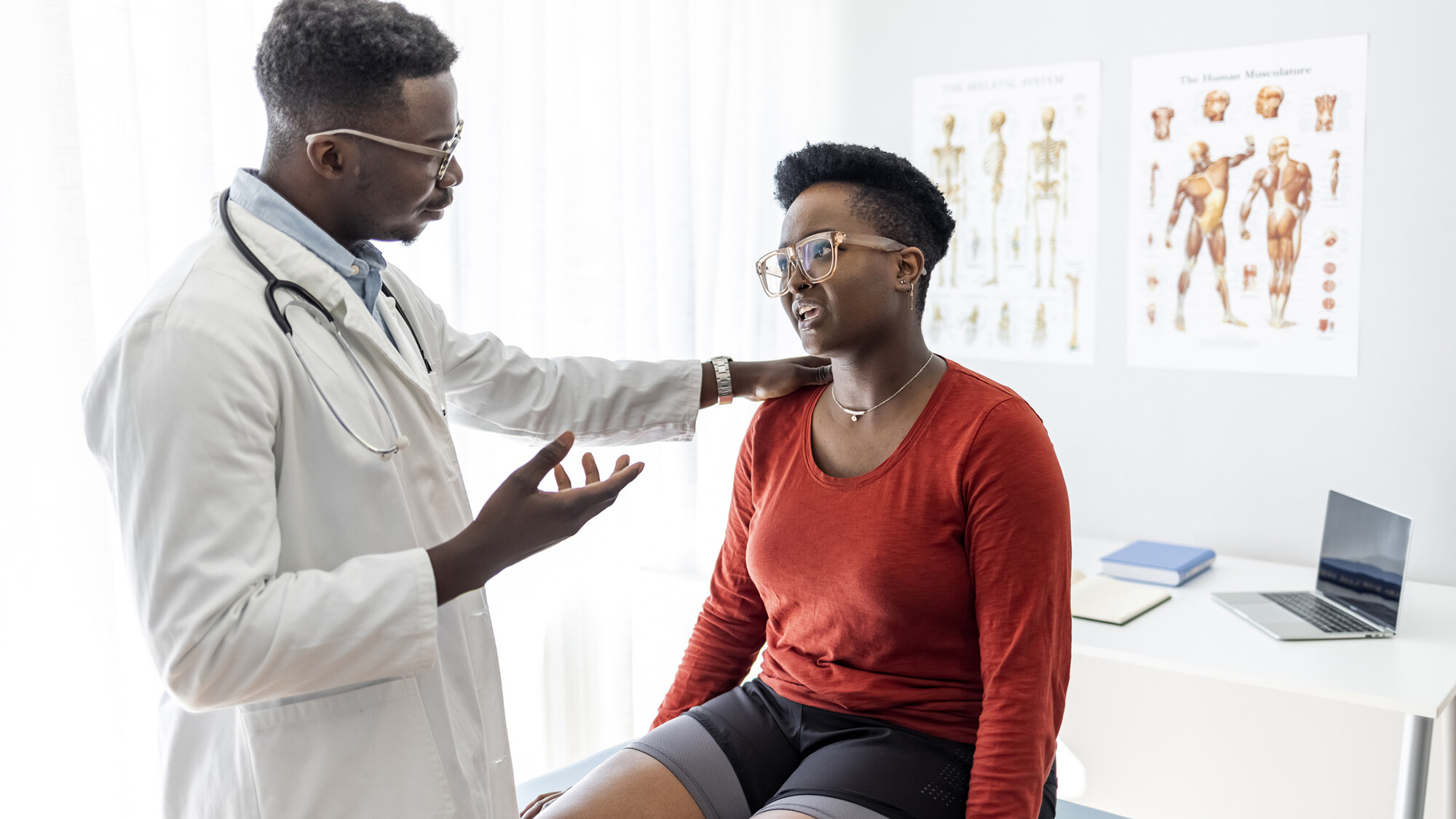 A doctor speaks with a patient in a doctor's office.
