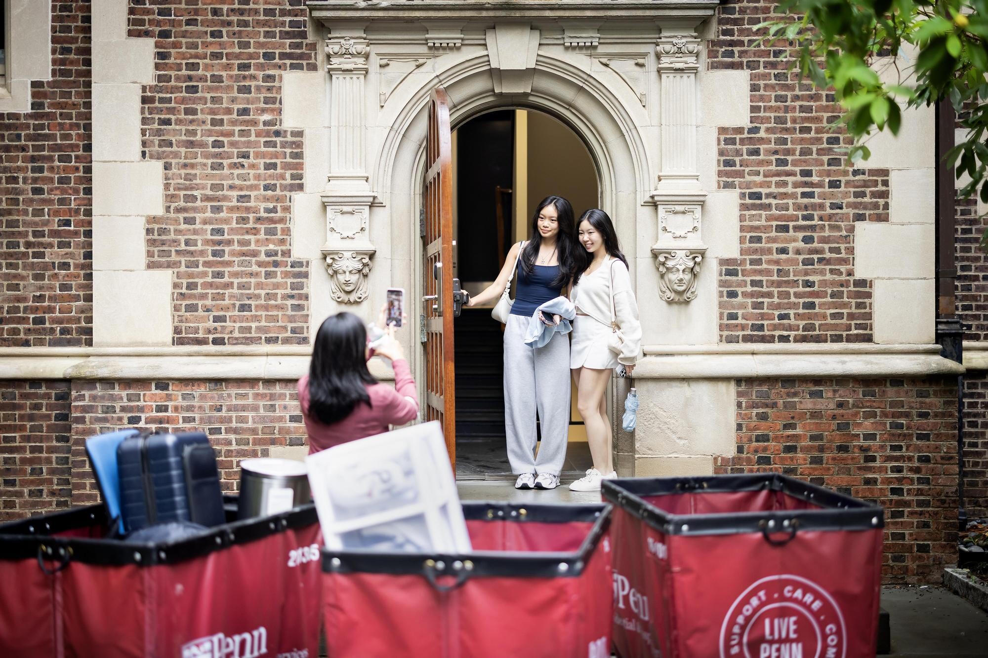 Two students posing for a picture outside a Penn College House during Move-In.