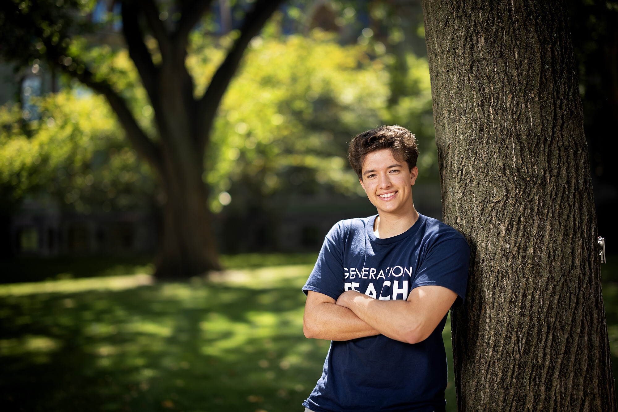 Cole DuHaime leans against a tree wearing a Generation Teach shirt.