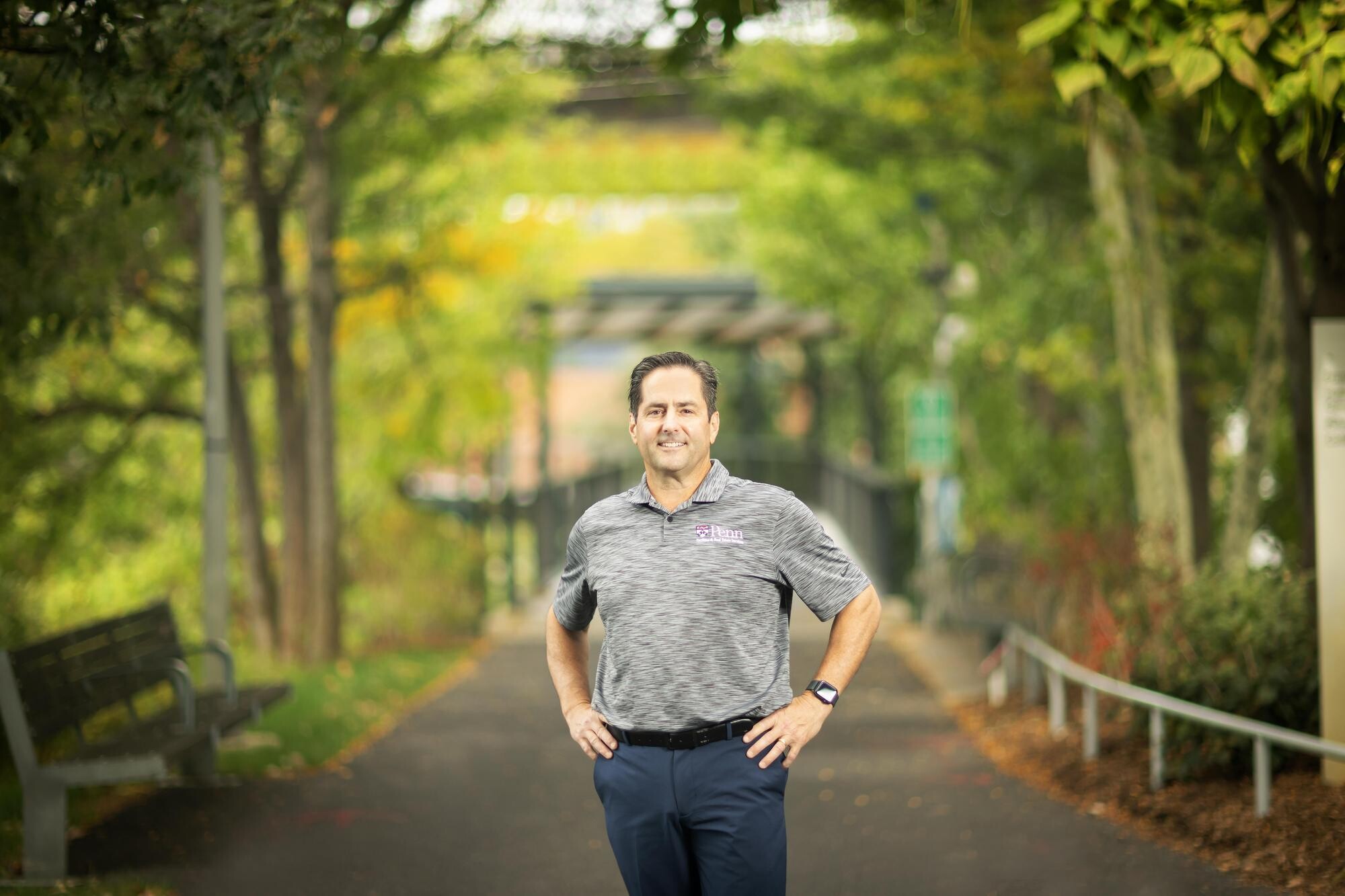 Craig Roncace, Penn’s urban park manager, standing outside in a park setting with a Penn shirt. 