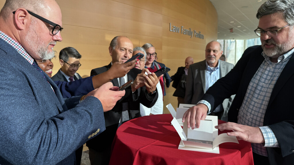 John Bence shows the X-ray plates to people at Penn Medicine who are taking photos of them.