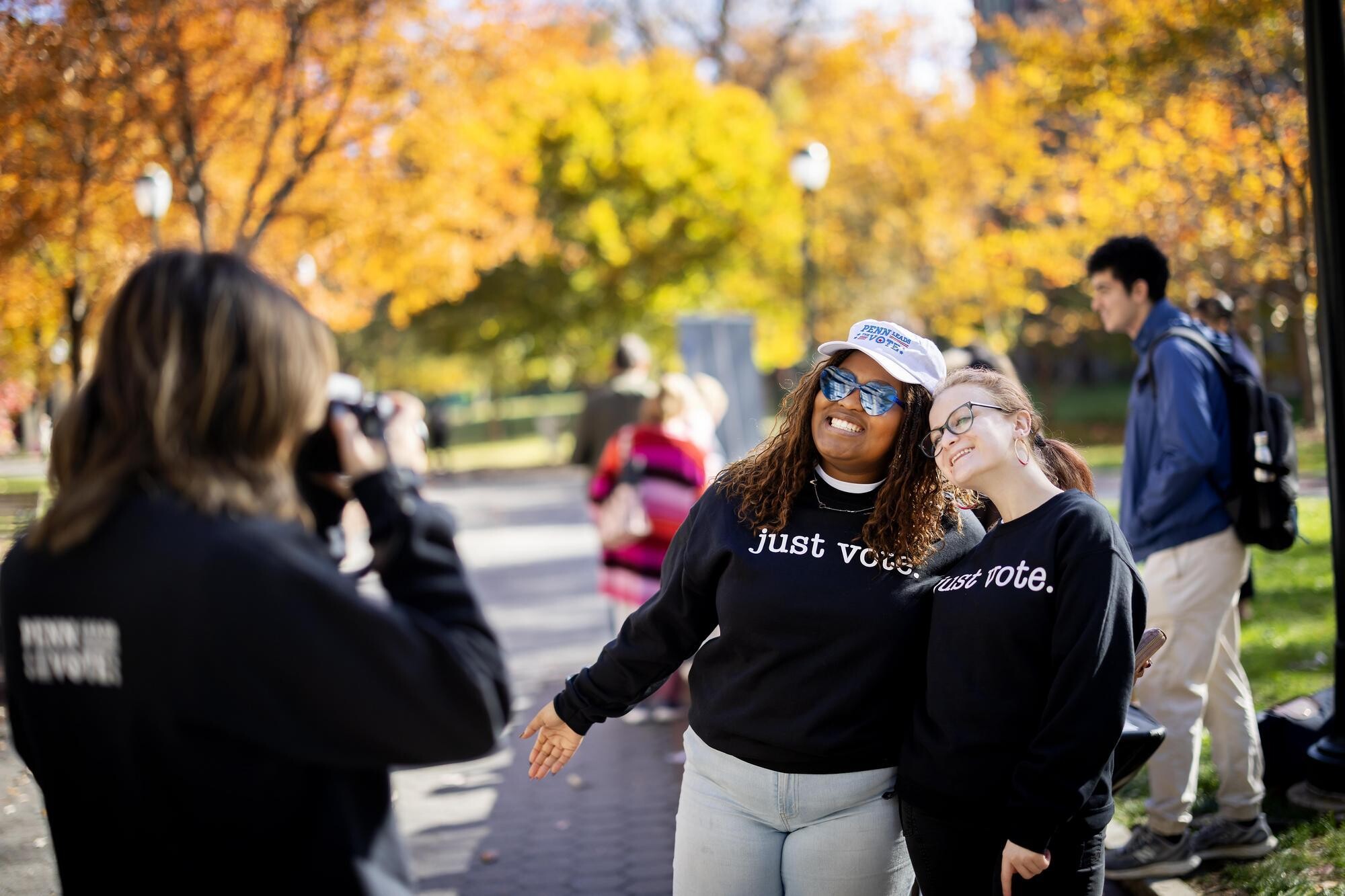 A person taking a picture of two PLTV volunteers on Locust walk.