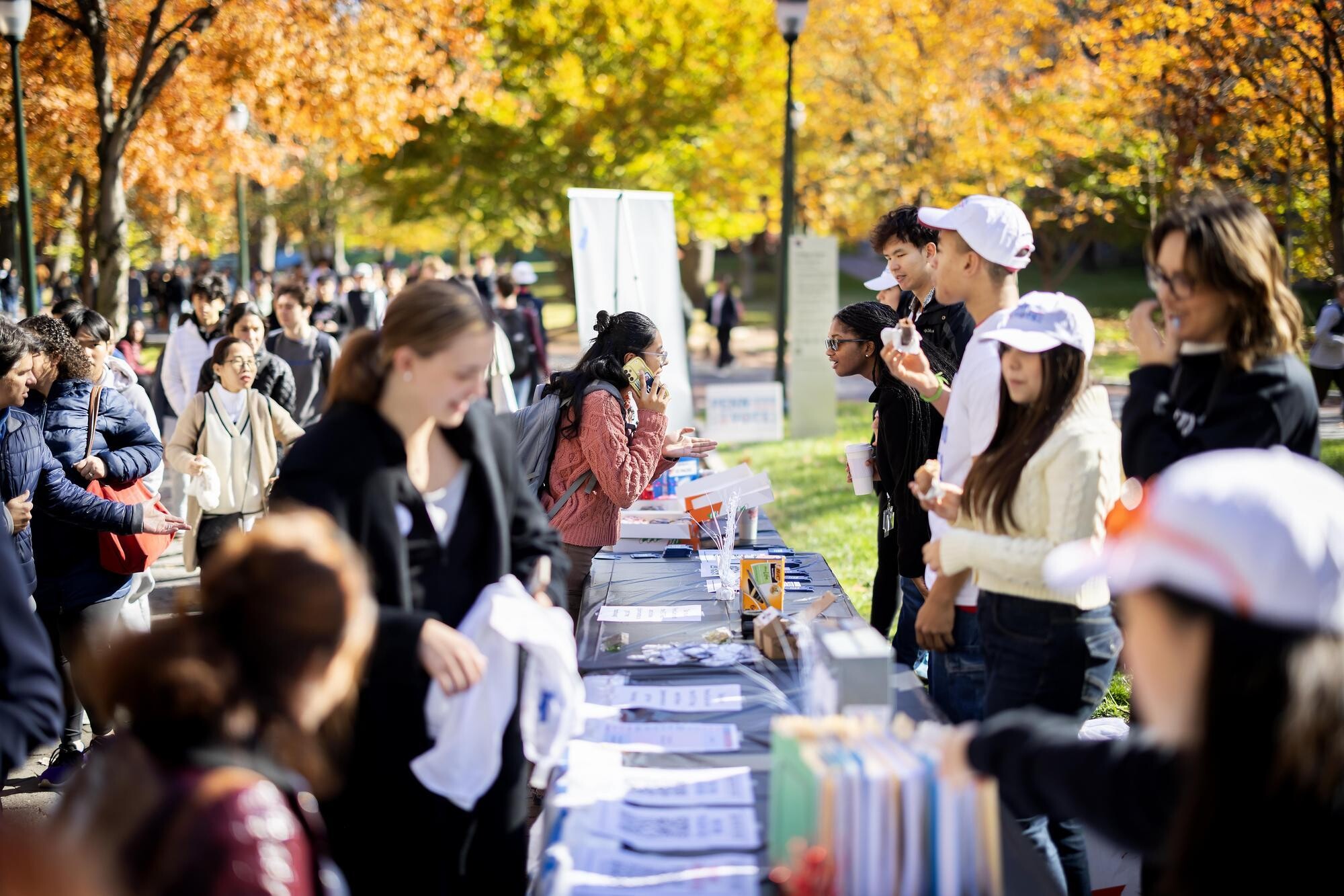 Penn Leads the Vote volunteers at tables talking to students walking by on Locust Walk.
