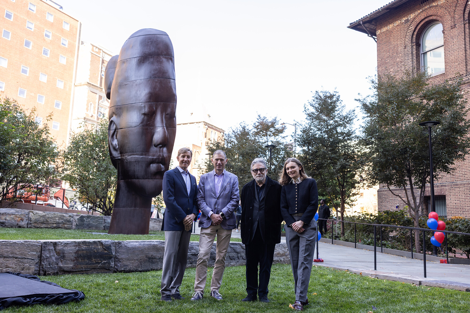 Penn President J. Larry Jameson, Glenn Fuhrman, Jaume Plensa, and Ava Cappitelli in front of the Rui Rui sculpture.