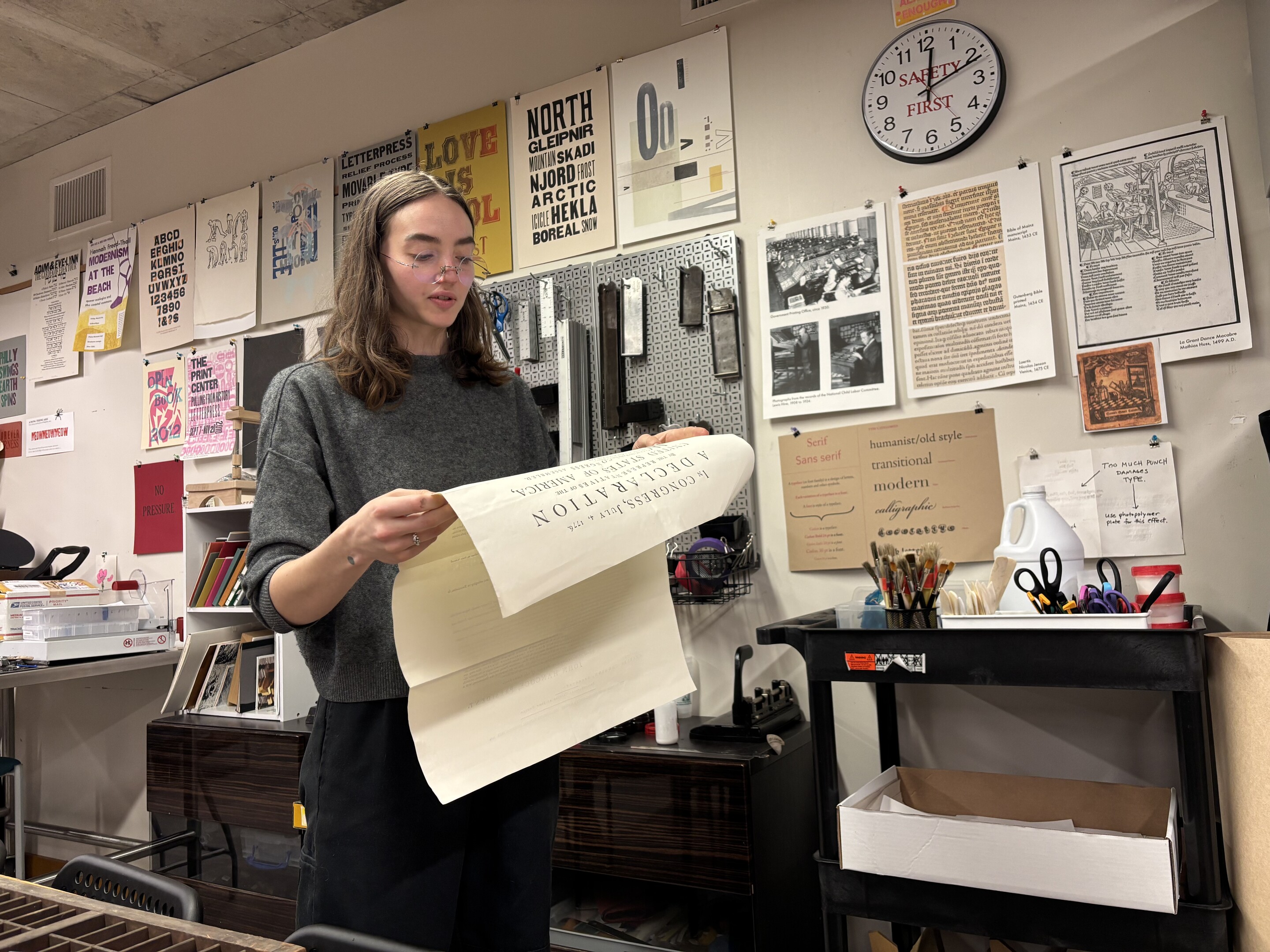 A worker at Common Press reading from a historic document.