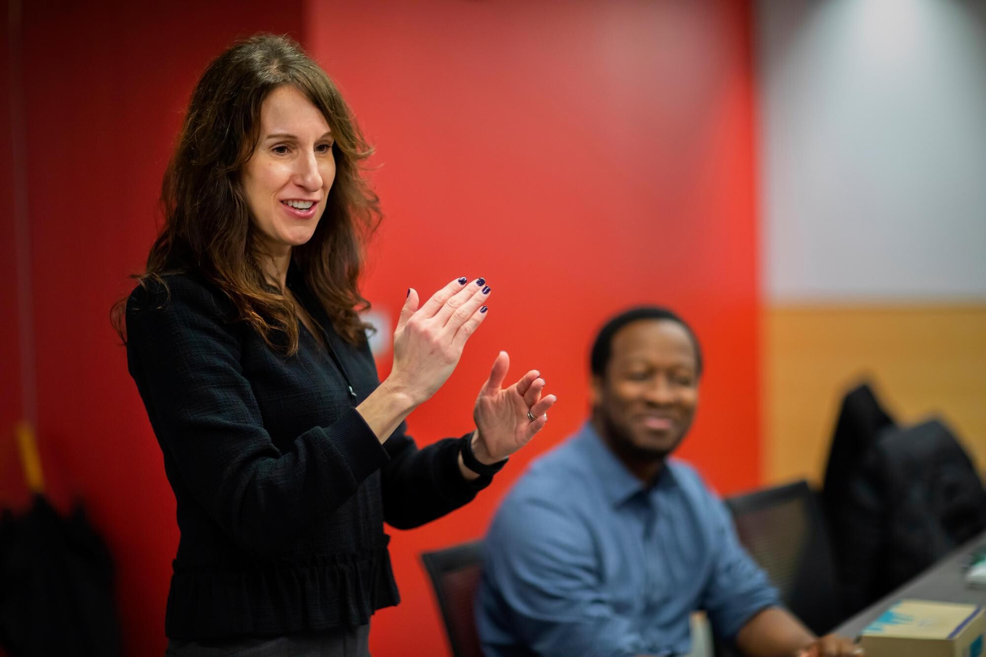 Karen Reivich smiling and hand gesturing while teaching a resilience workshop.