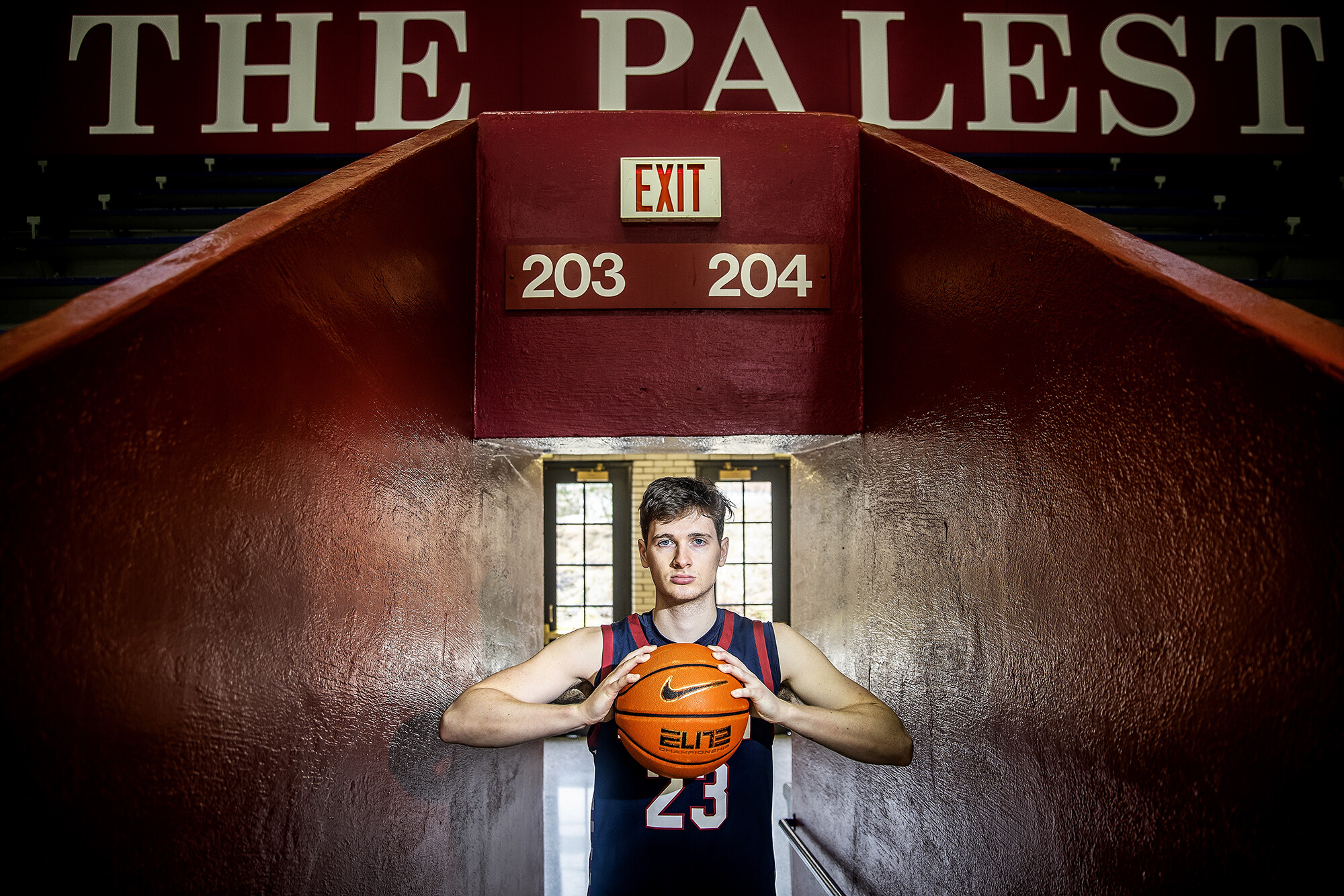 Ethan Roberts holding a basketball at the entrance to the Palestra.