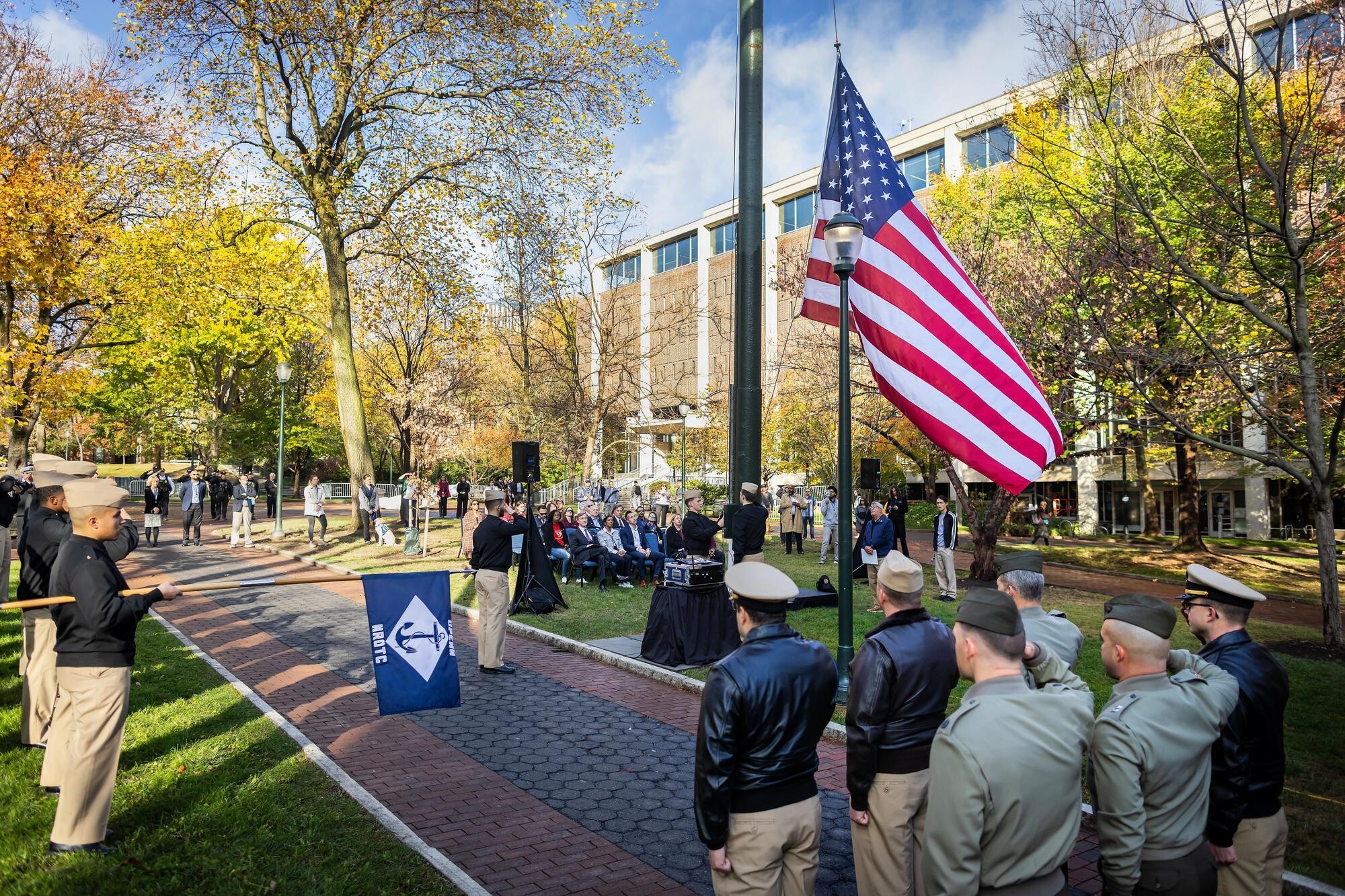 Military veterans saluting the American flag on Penn’s campus.