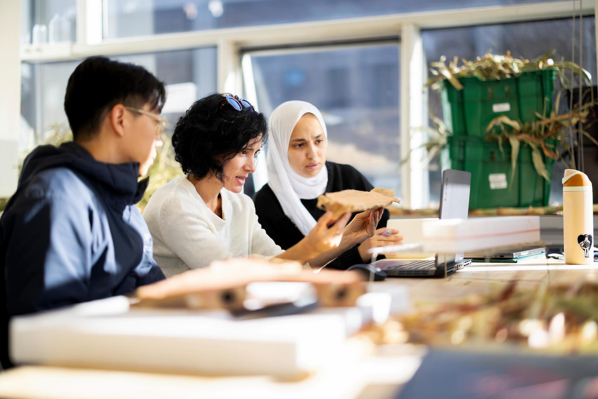 Laia Mogas-Soldevila and two students looking at food waste in a lab.