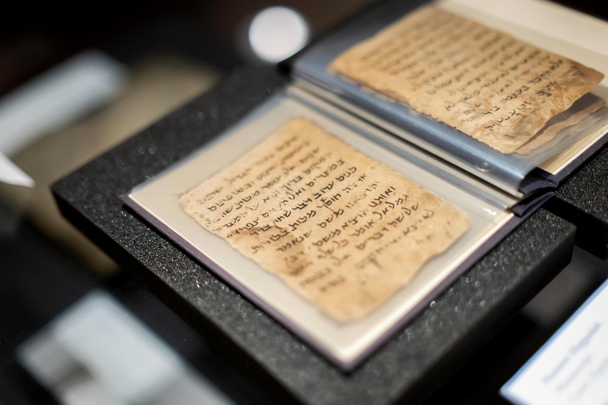 The Dropsie Haggadah, laminated in a protective booklet, with Hebrew letters and yellowing pages. 