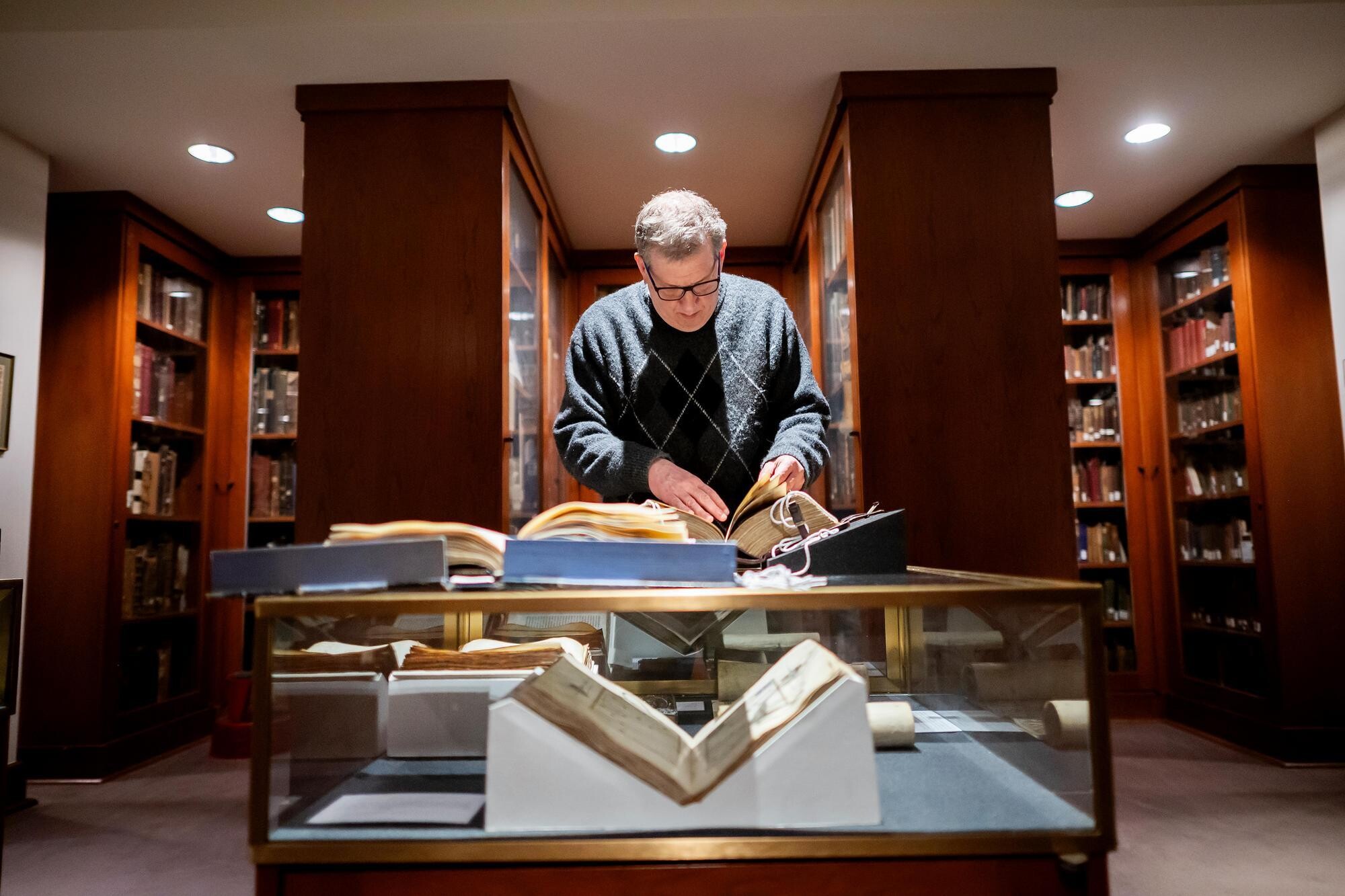 Steven Weitzman flipping through artifact books in the Library at the Herbert D. Katz Center for Advanced Judaic Studies