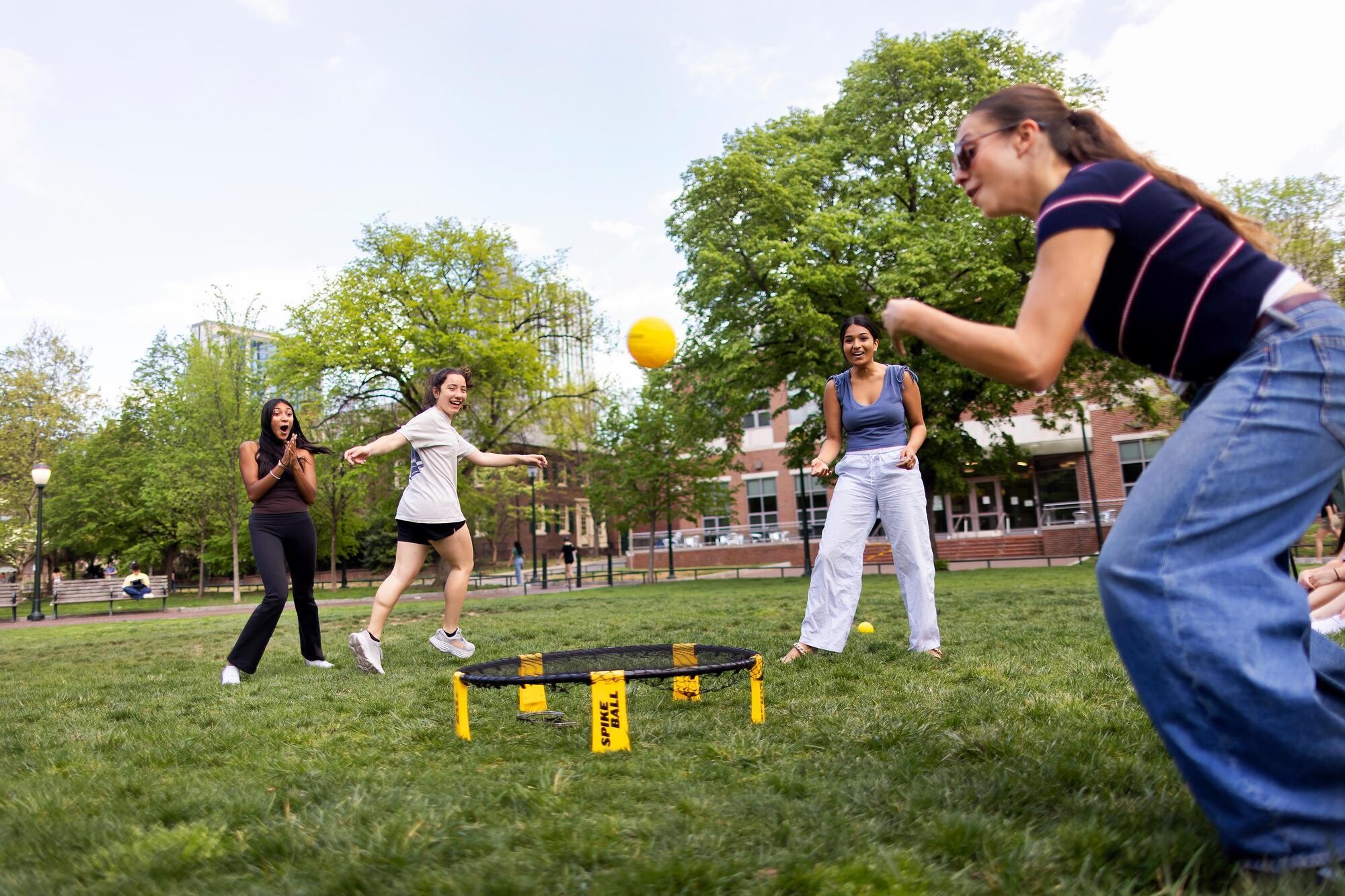Four students playing spikeball on High Rise Field.